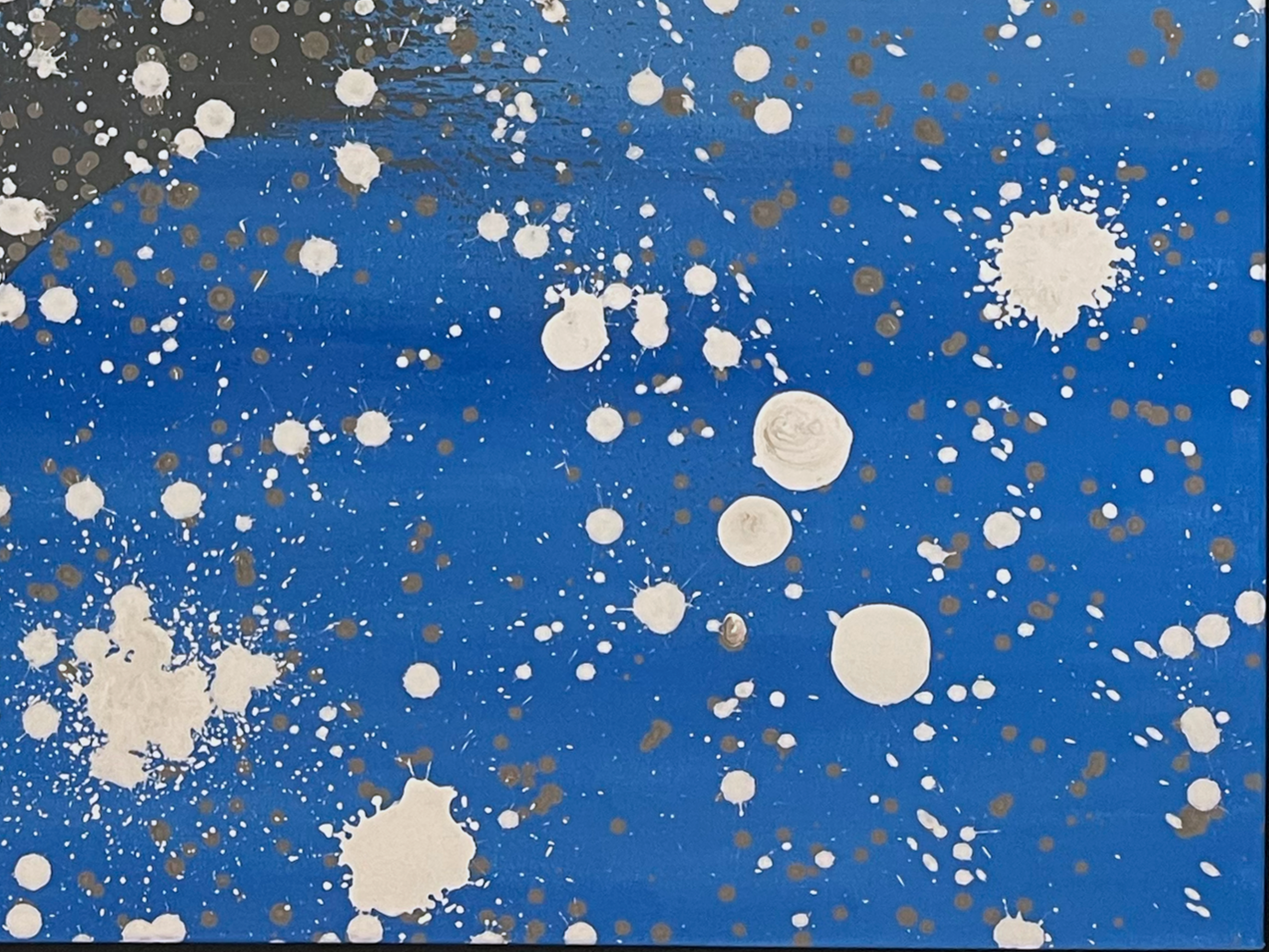 Blue background with white and brown paint splatters in a splattered pattern.