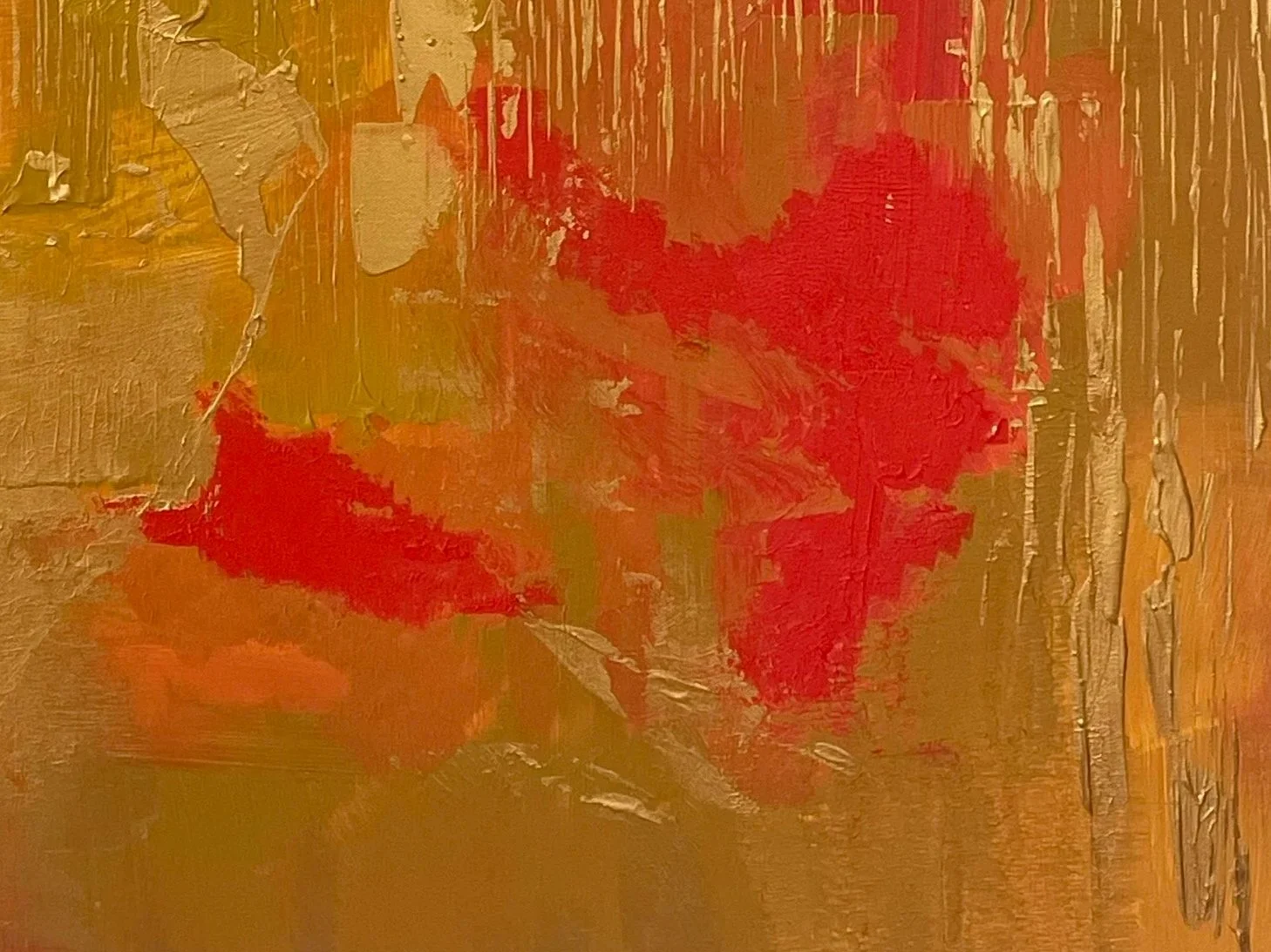 Abstract painting with textured gold and red streaks and patches.