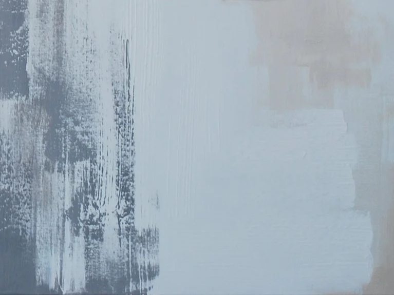 Abstract painted wall with white and gray brush strokes.