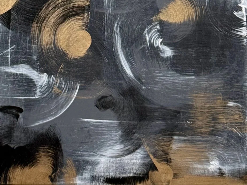 Abstract painting with bold black, white, and gold brushstrokes creating circular and swirling patterns.