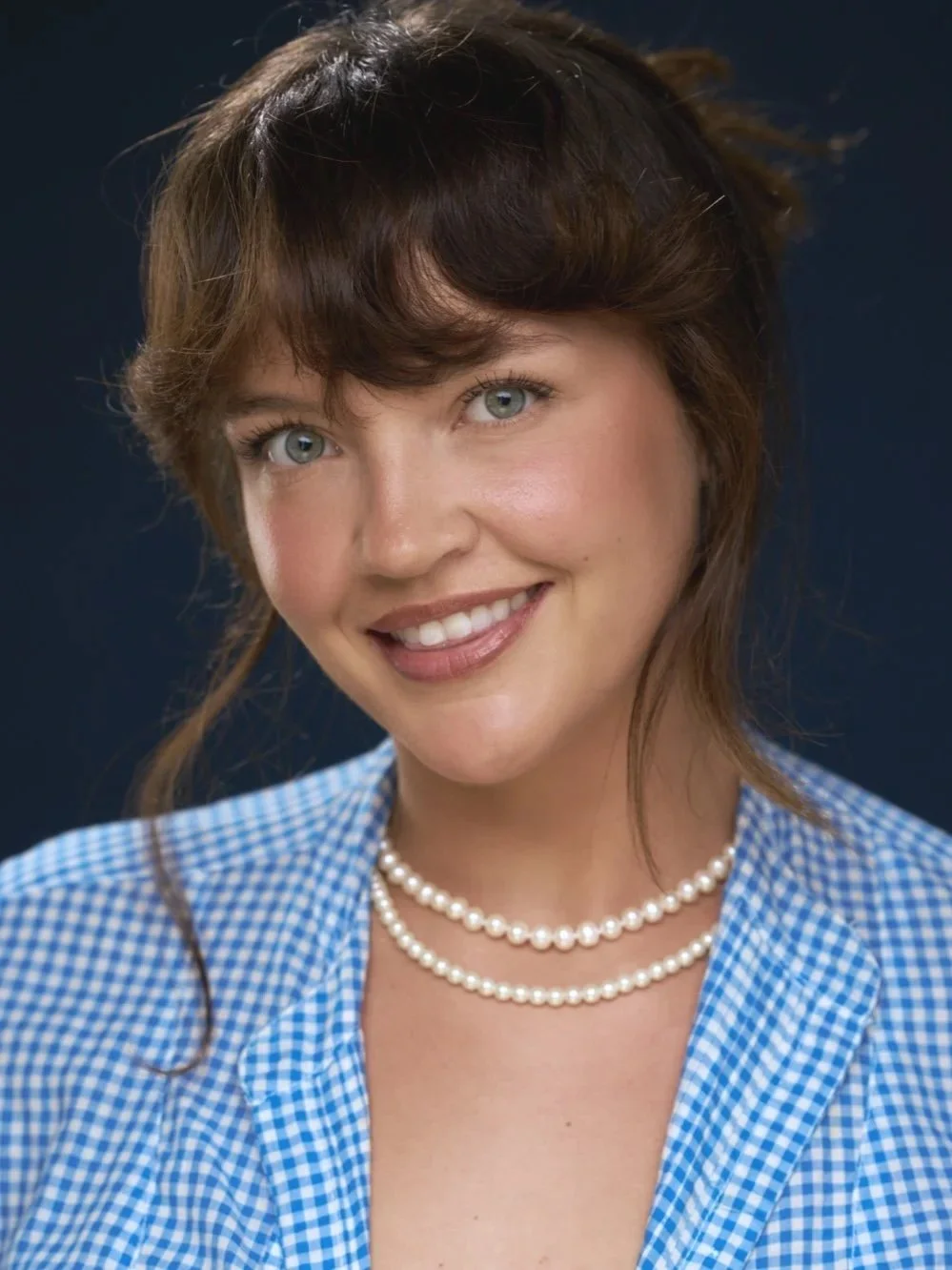 Emily Greene, Head of Singing & Acting Integration at Seren Arts Hollywood, smiling in a blue gingham top