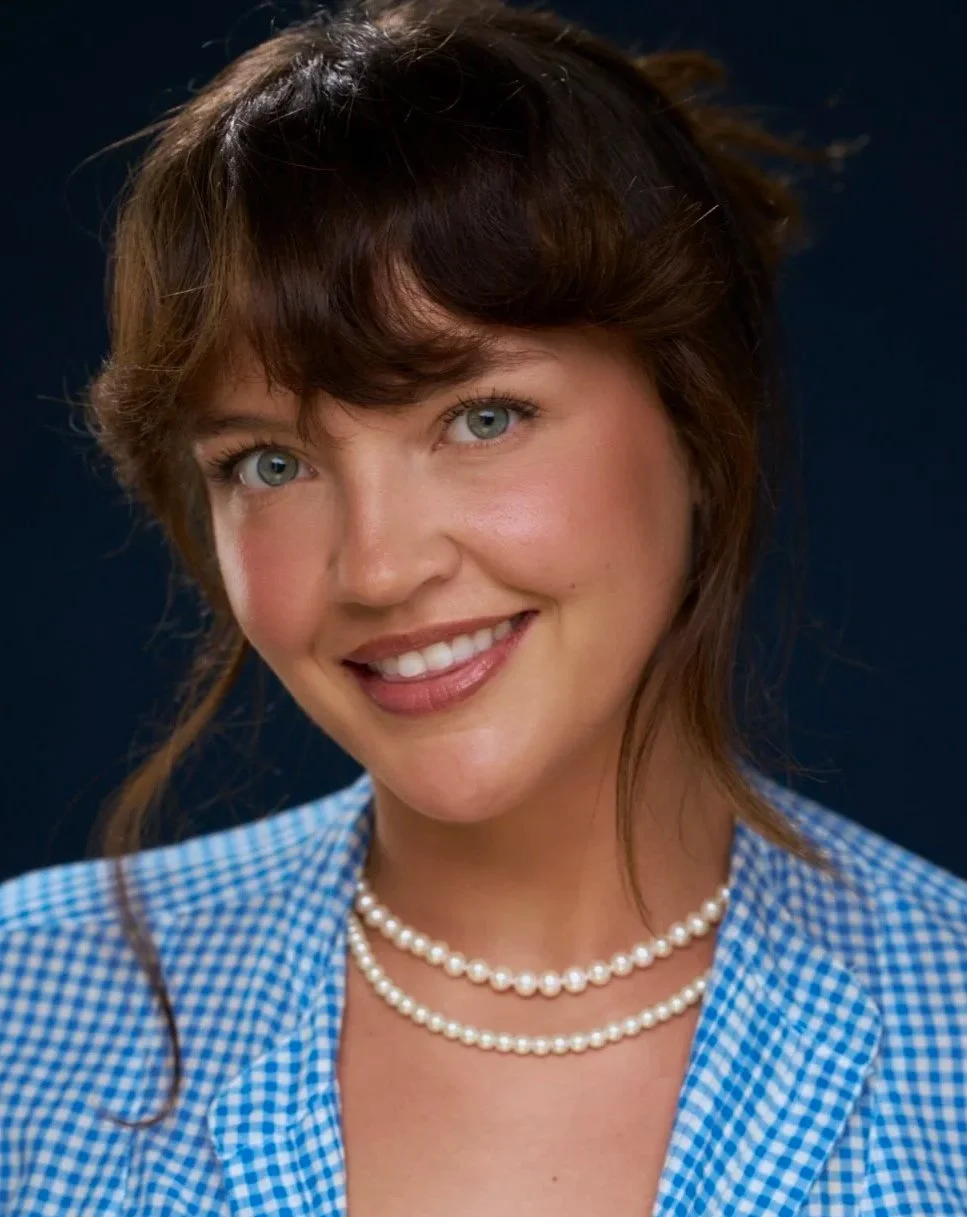 Emily Greene, Head of Singing & Acting Integration at Seren Arts Hollywood, smiling in a blue gingham top