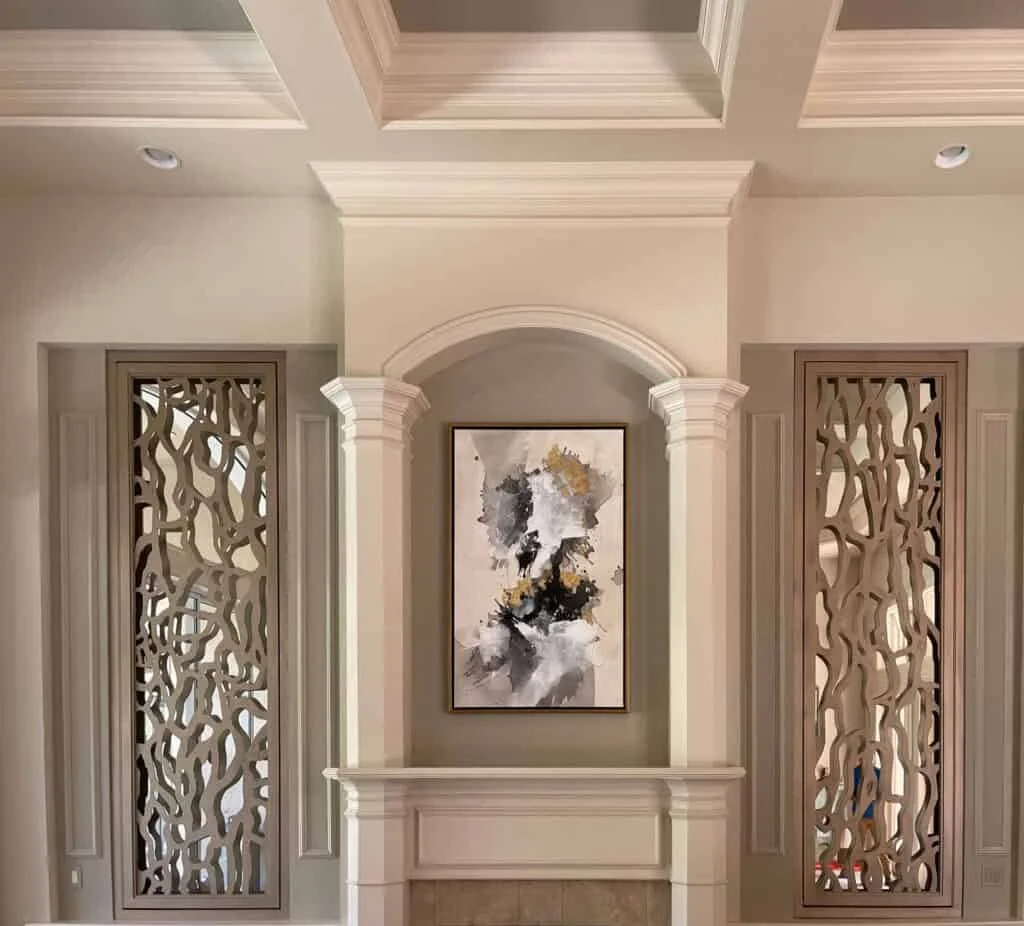 Interior of a living room with a fireplace, decorative columns, and an abstract painting on the wall.