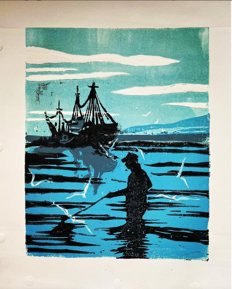 Silhouette of a person fishing in shallow water near a dock with sailboats and a cloudy sky in the background.