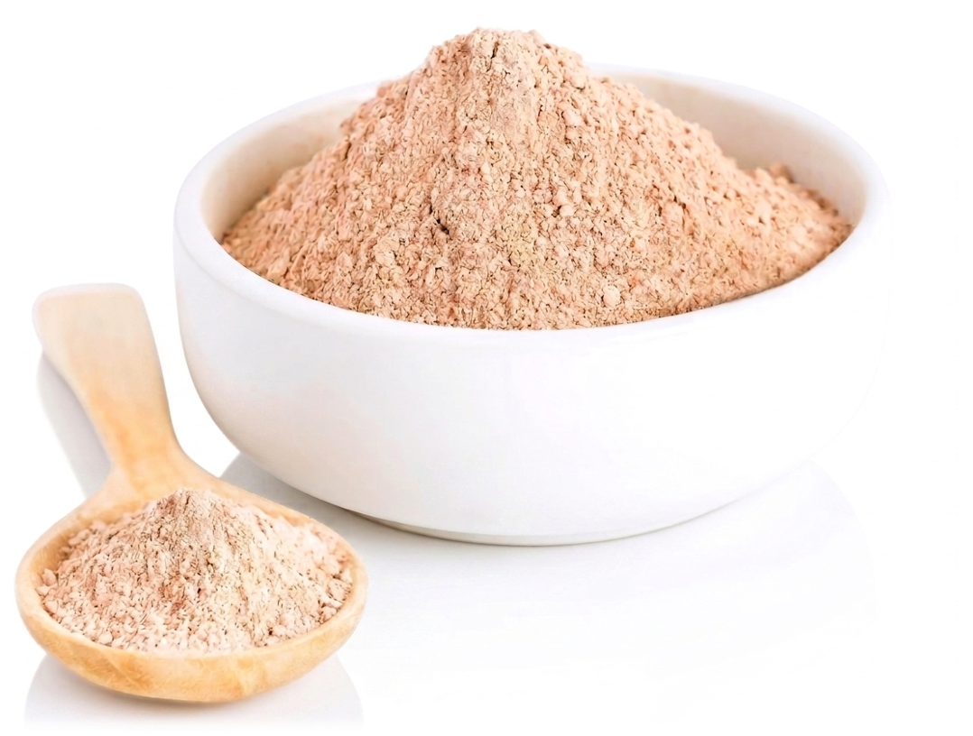 A white bowl filled with light brown powder and a small wooden scoop also containing the powder.