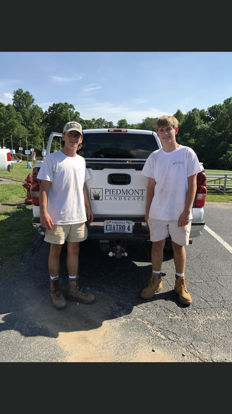 Original photo of the co-founders standing in front of a white pickup truck in an outdoor setting with clear blue skies and green trees in the background.