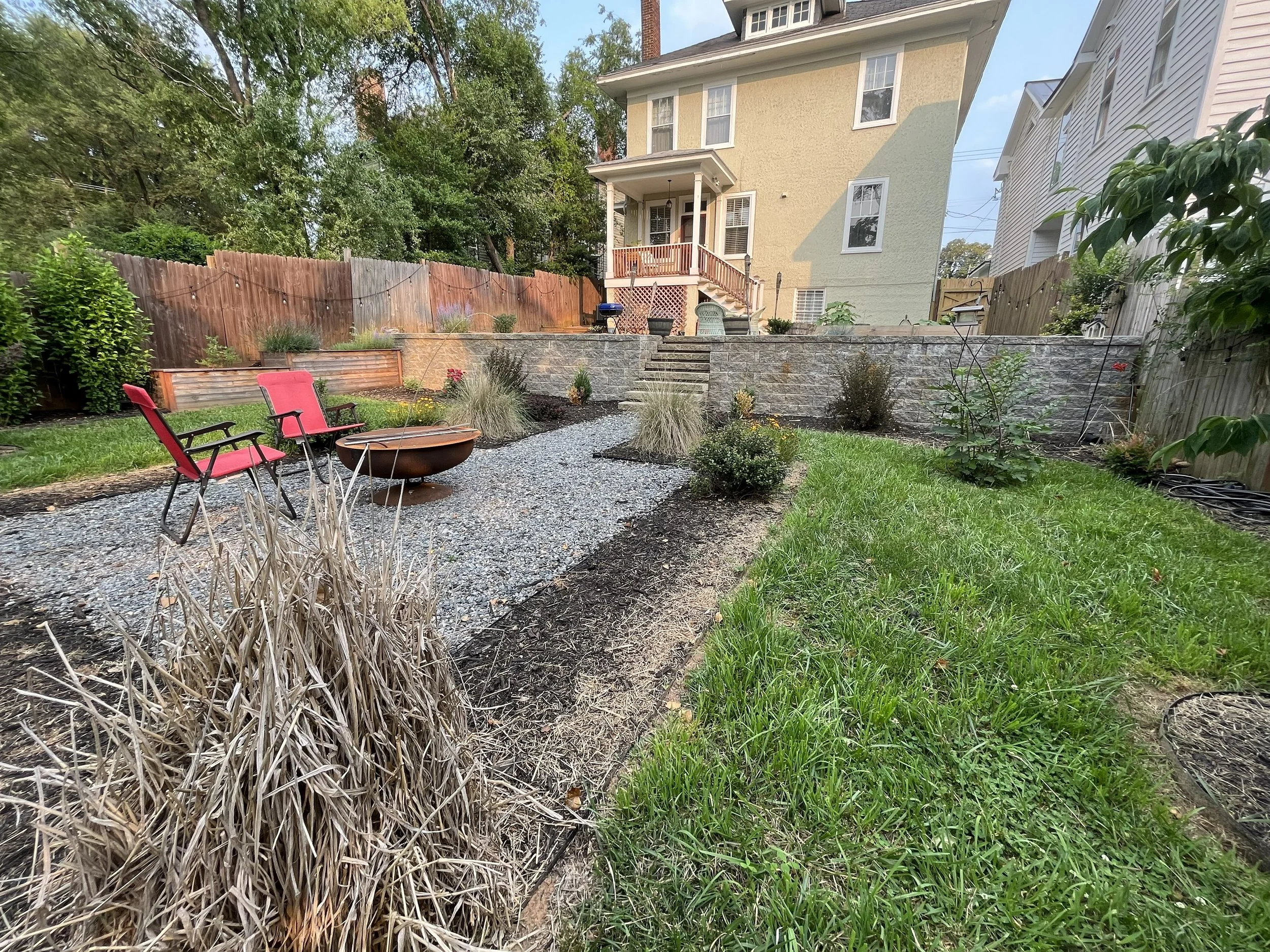 Outdoor Living Space Construction including retaining walls, plants, and staircase.