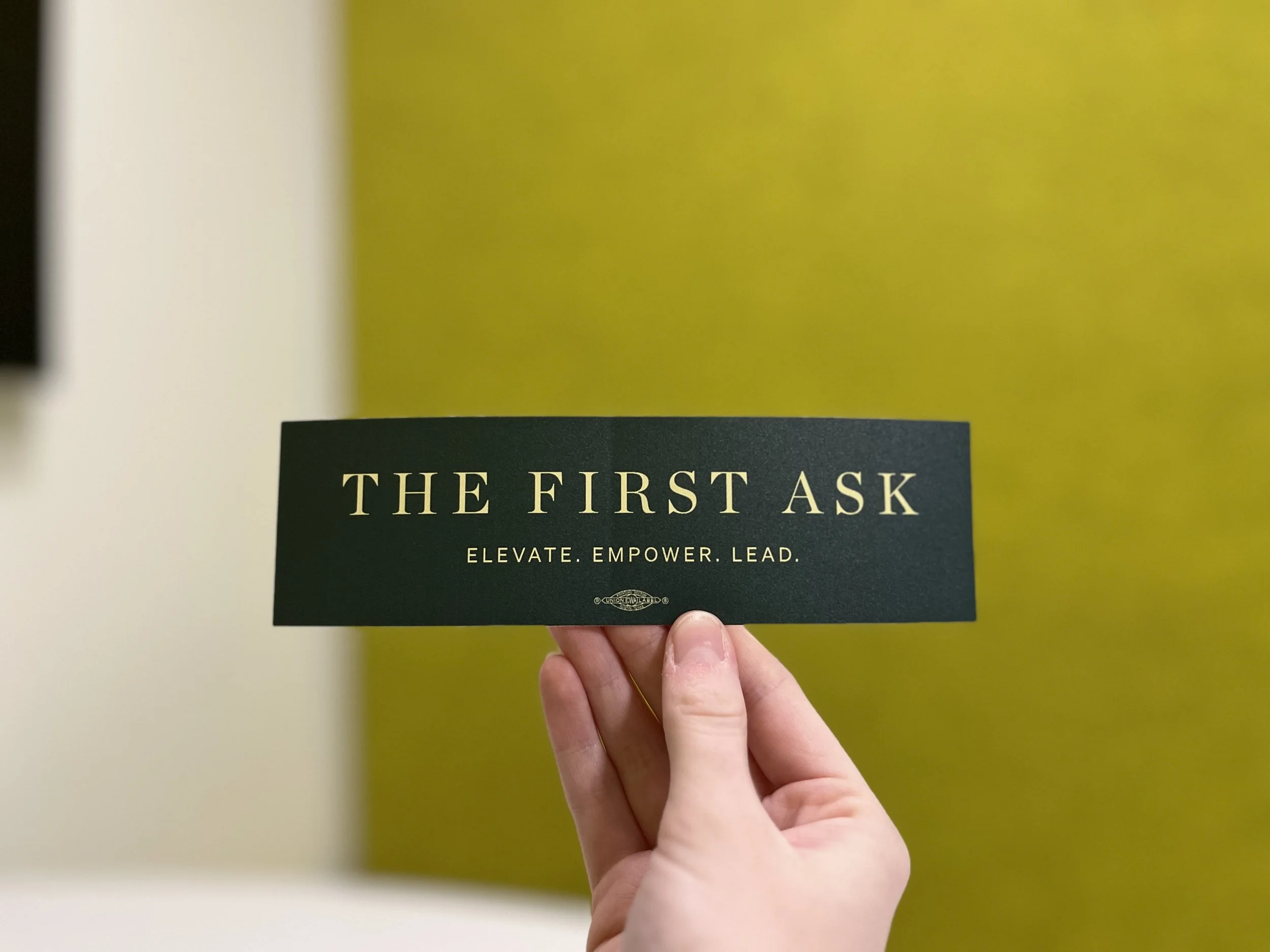 Elevate Empower Lead Sticker - Dark green rectangular sticker that says "The First Ask. Elevate. Empower. Lead." in light green text.