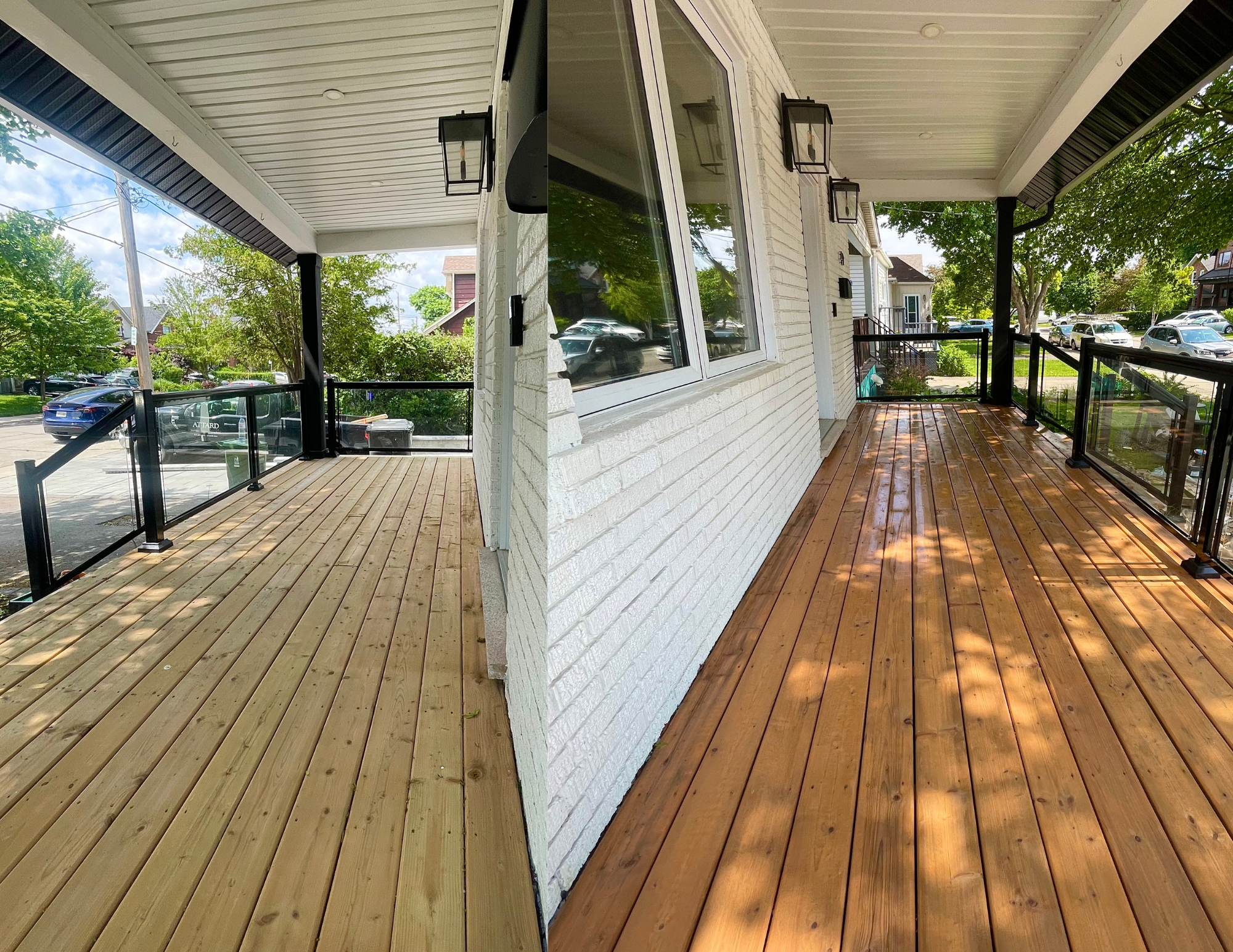 Side view of a house porch with wooden flooring, white brick wall, glass railing, black lantern lights, trees, and parked cars in the background.