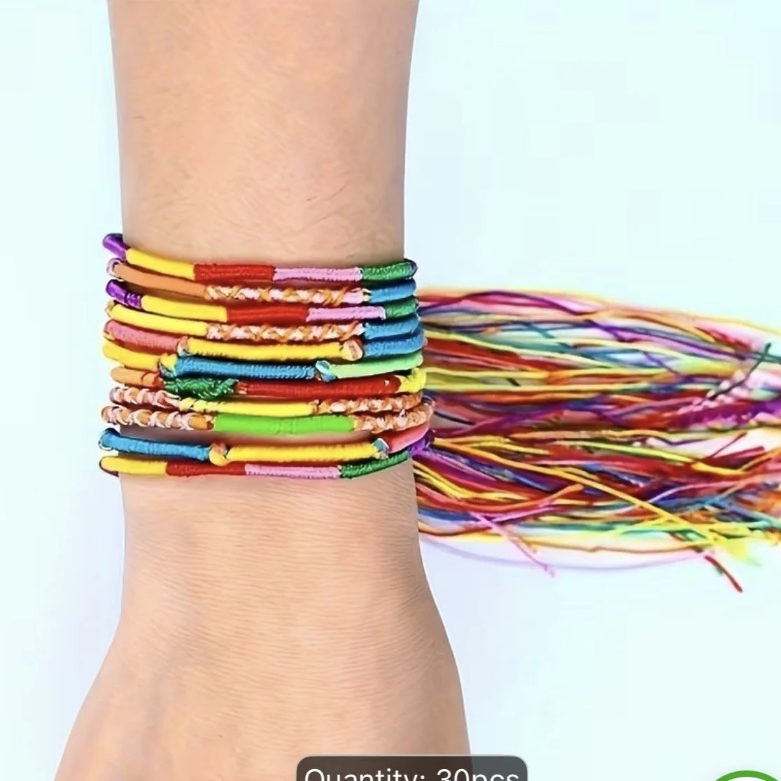 Colorful thread bracelets on a person's wrist.