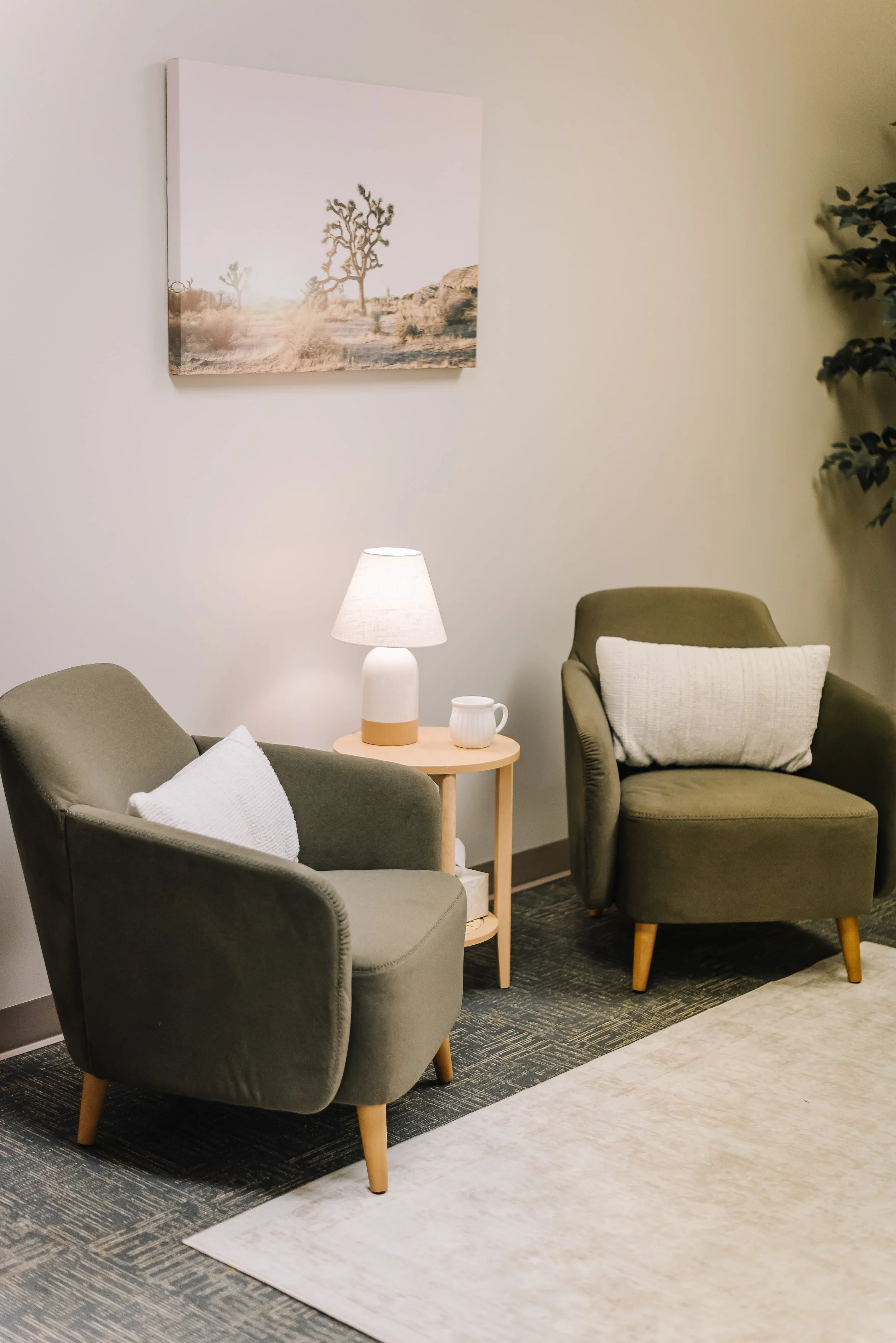 Comfortable grief counseling office with two green chairs and calming decor at Bond Grief Collective in Manhattan, Kansas.