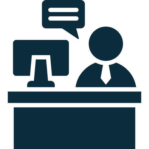 Icon of a person sitting at a desk with a computer, with a speech bubble indicating communication or conversation.