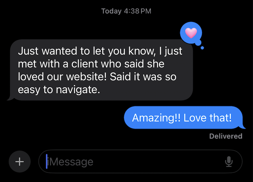 Text message conversation on a smartphone screen. The first message says, 'Just wanted to let you know, I just met with a client who said she loved our website! Said it was so easy to navigate.' The second message responds with, 'Amazing!! Love that!' with a love heart emoji.