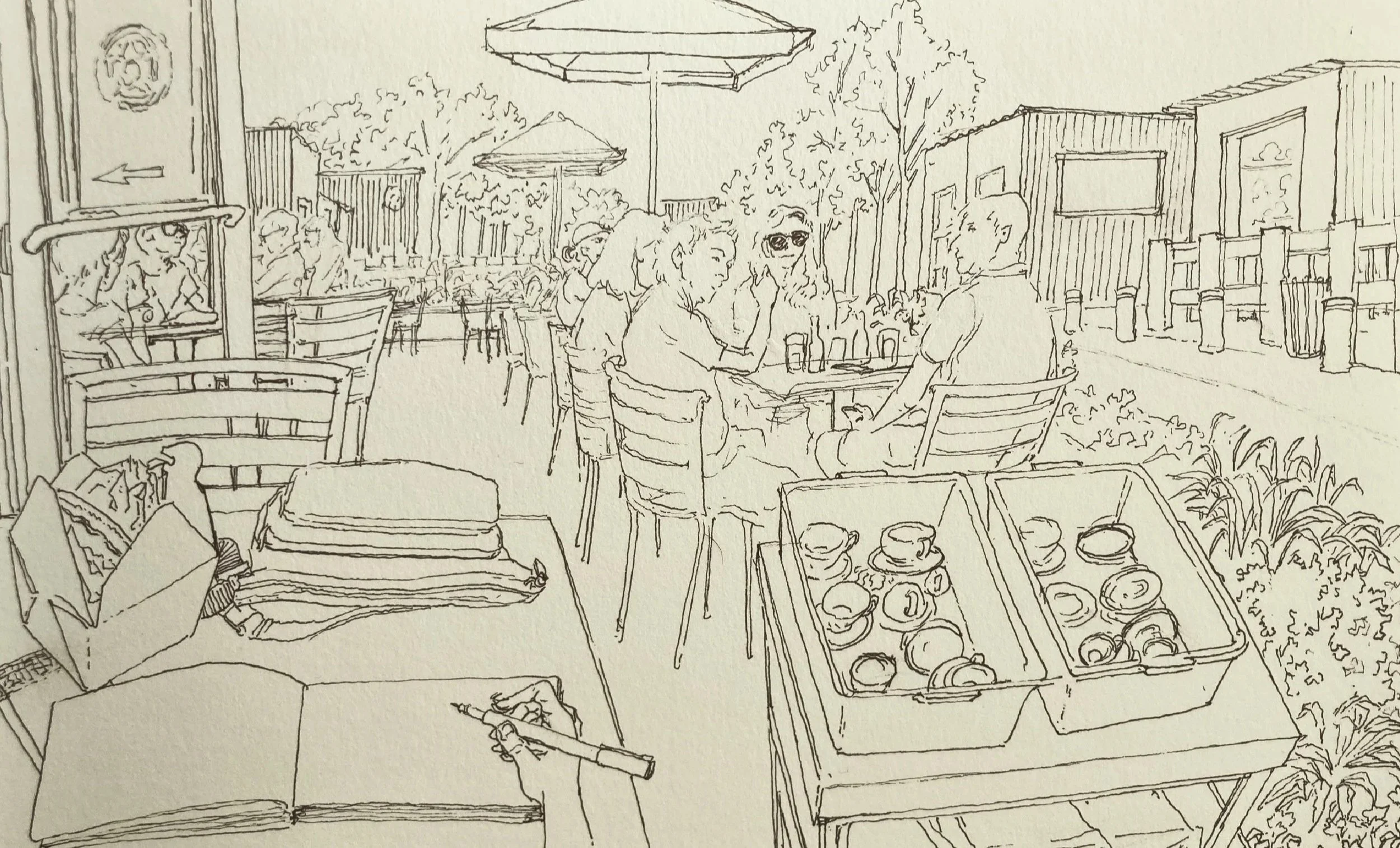 A sketch of outdoor café scene with people sitting at tables, umbrellas, and a sidewalk with storefronts and trees.