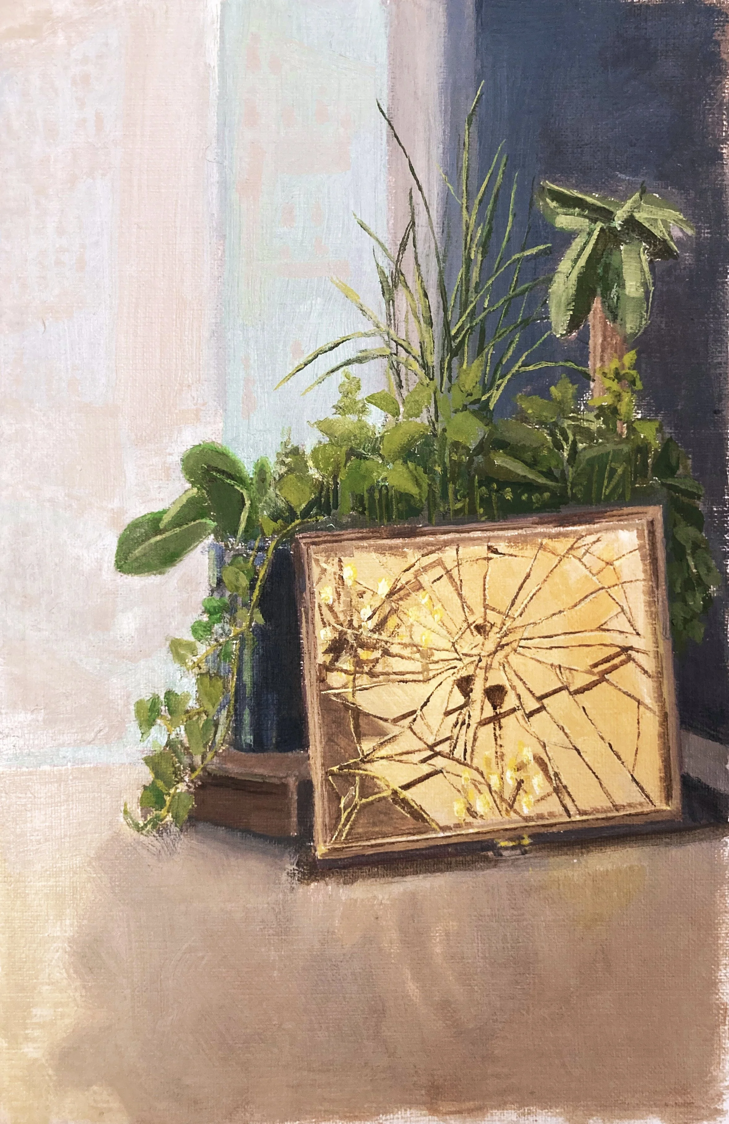 A still life painting of green houseplants and a lit candle inside a wooden frame, placed on a flat surface against a wall.
