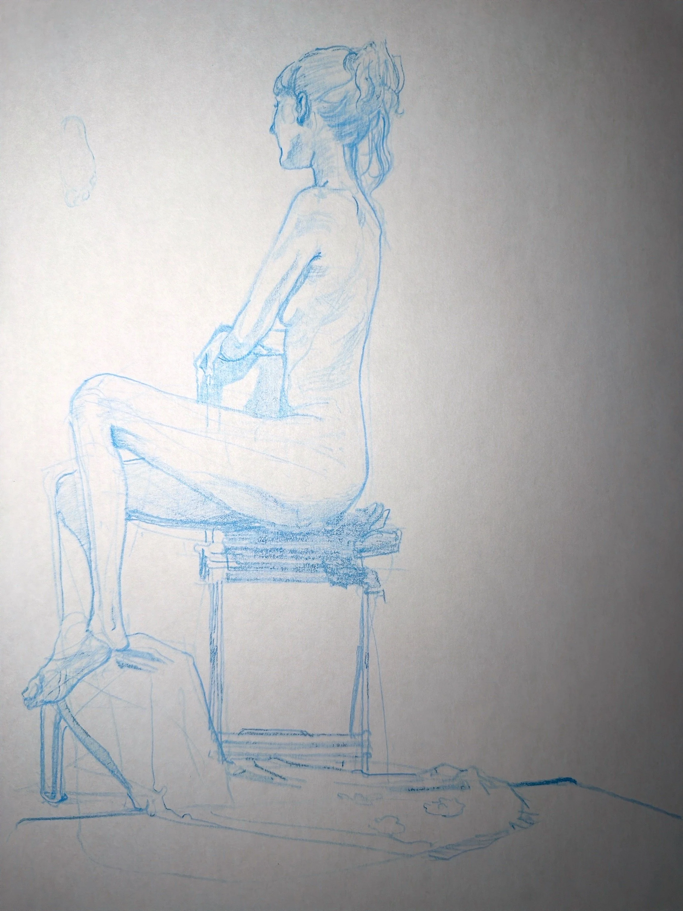 Sketch of a woman sitting on a chair with her hands resting on her lap, viewed from the side, drawn with blue pencil.