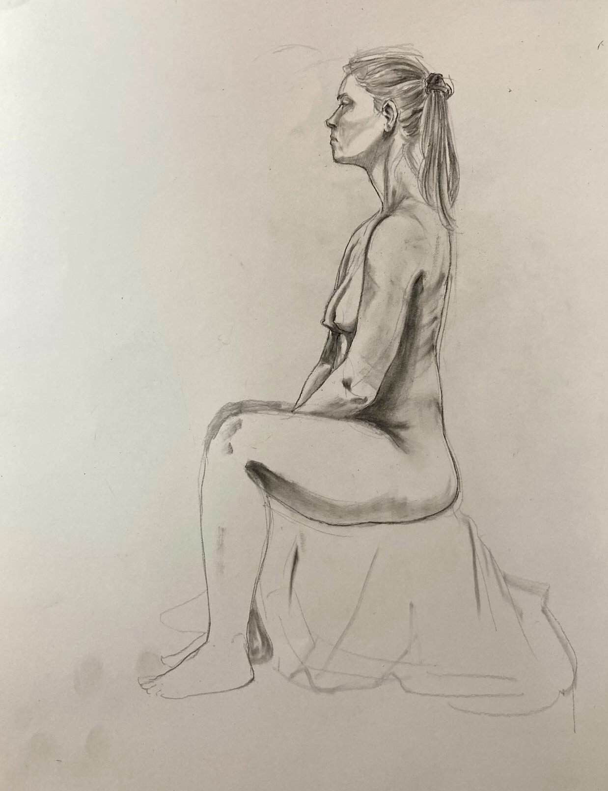 A pencil sketch of a seated woman with her profile visible, hair tied back, and sitting on a stool or block with her legs crossed.