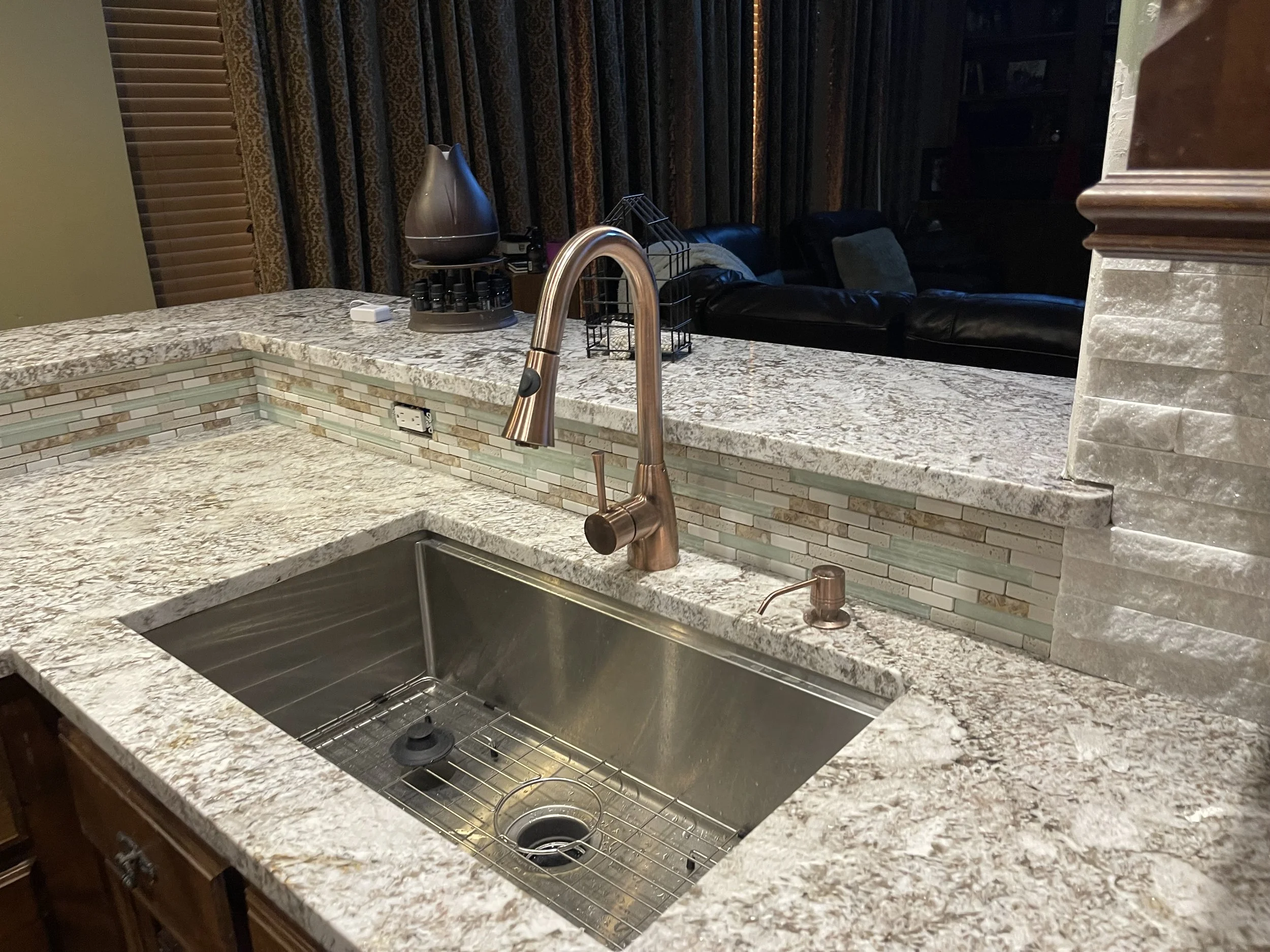 Kitchen tile backsplash in Norman, OK. Tile Backsplash in kitchen, glass, aluminum, and ceramic tile sheets behind faucet.