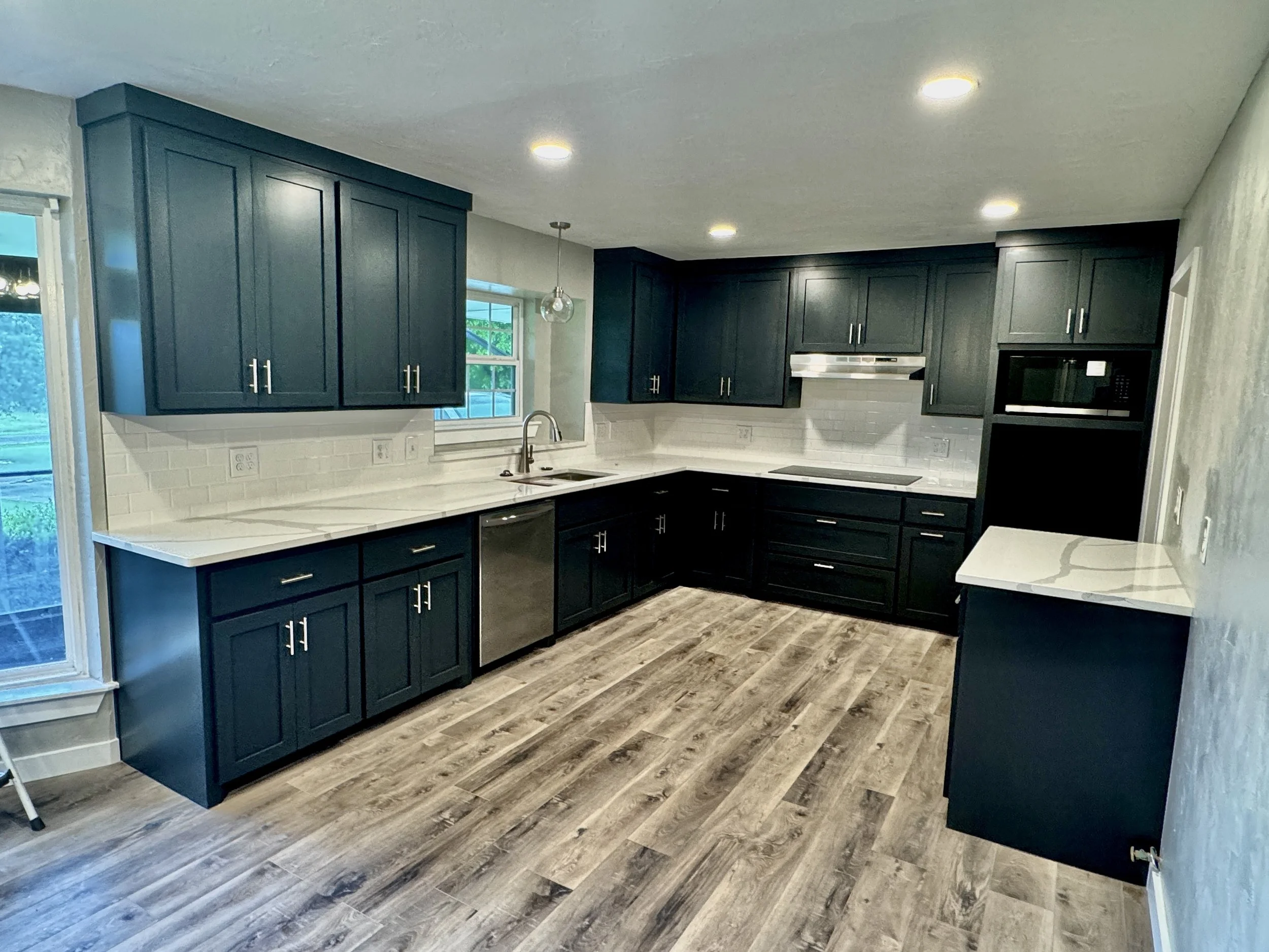 Kitchen remodel in Choctaw, OK with black custom cabinets and white quartz countertops.