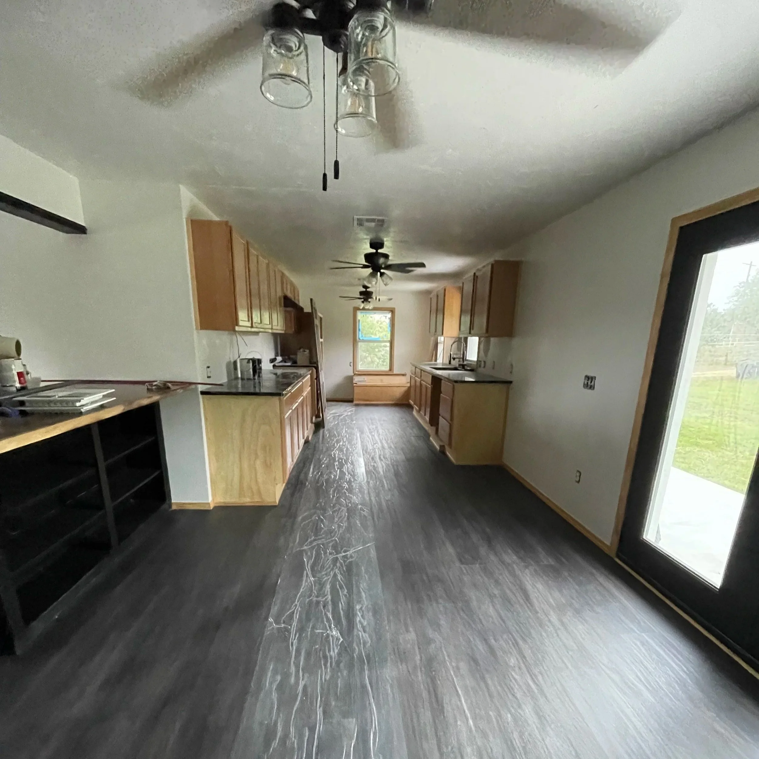 Home remodel in Midwest City, OK vinyl plank flooring, custom cabinets installed, black countertops, custom bar with live edge countertops, interior painting.