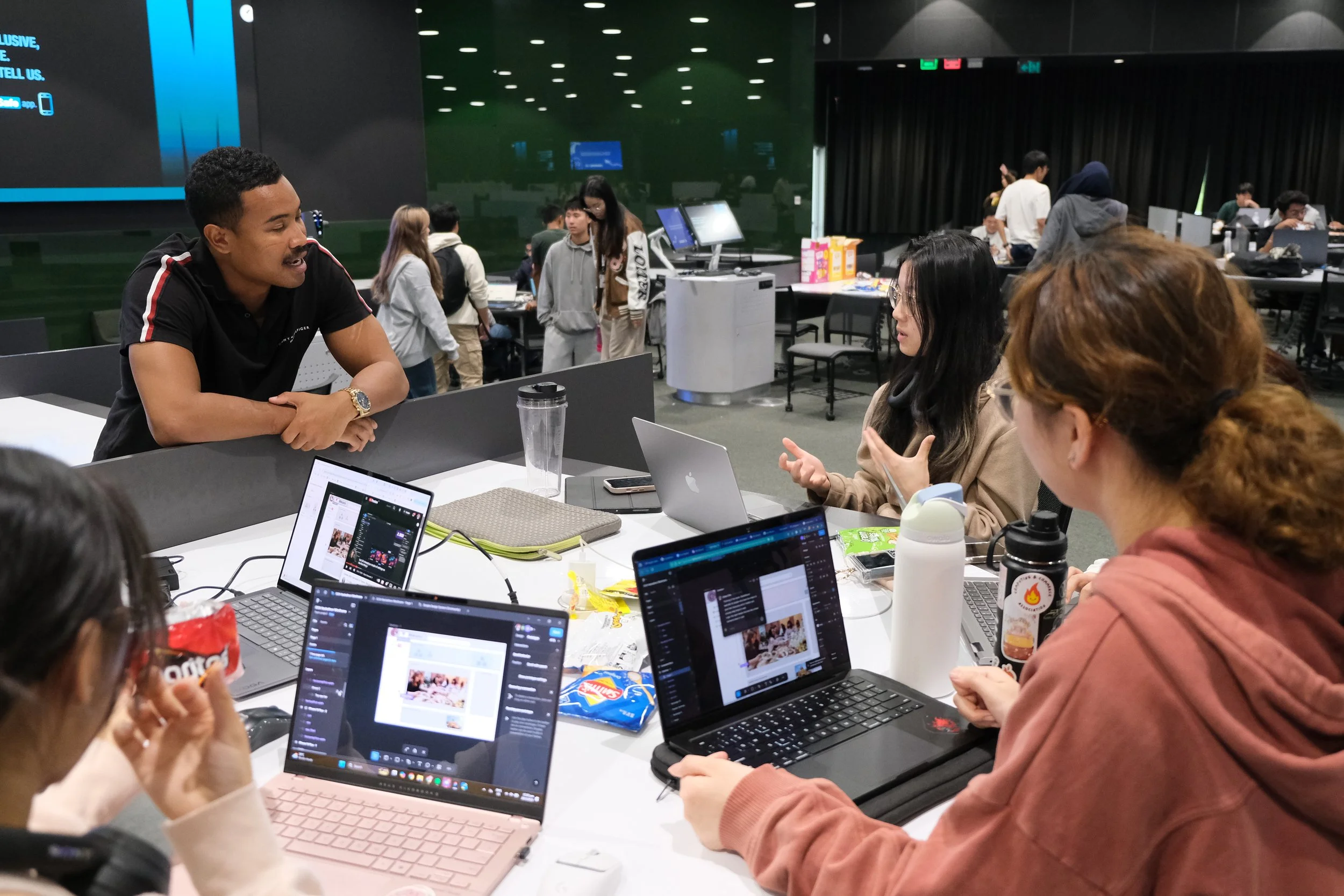 CCA x Mobilise 2025 Hackathon: organiser discussing with students about their project