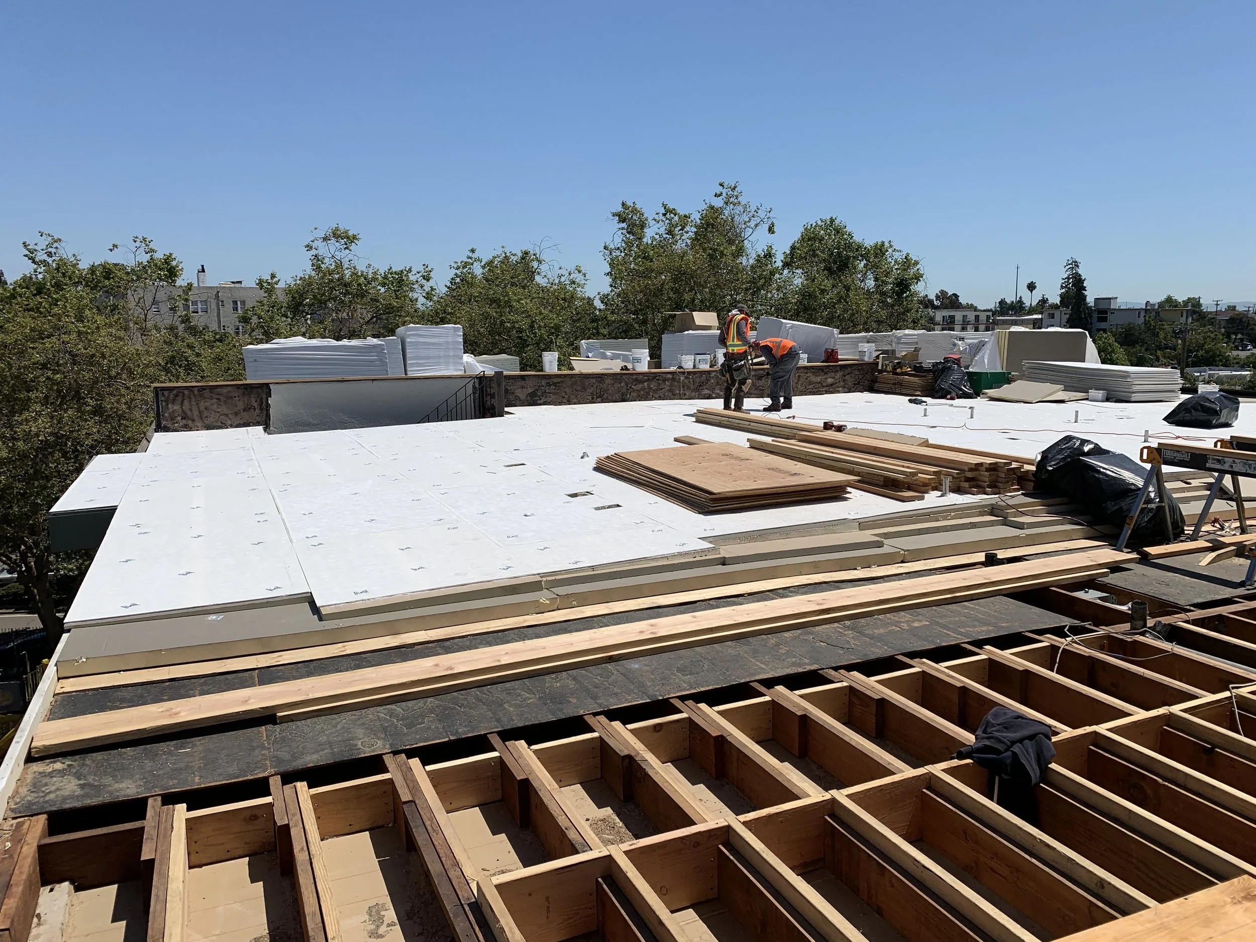 Construction workers installing an insulated roofing system.