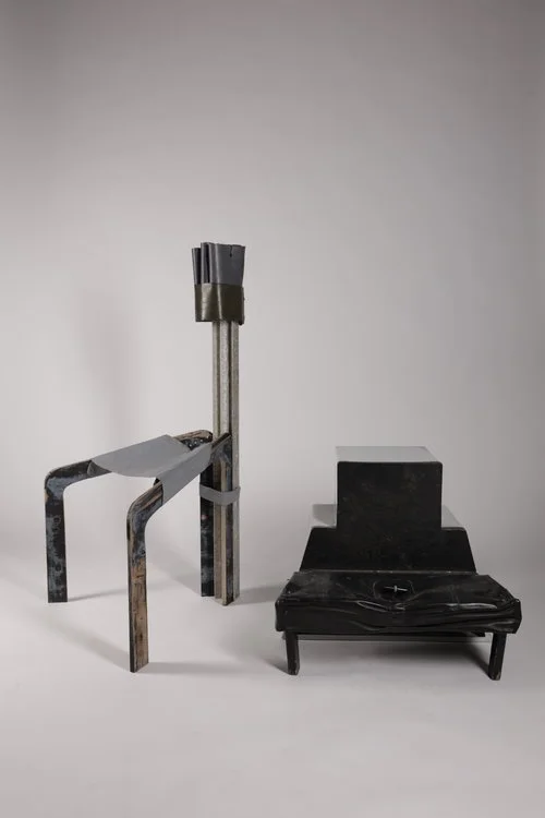 Three metal furniture pieces, a chair, a small table, and a rectangular stool, arranged on a light gray background.