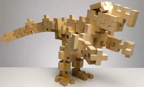 A large dinosaur sculpture made from interlocking wooden blocks, resembling a T-Rex.