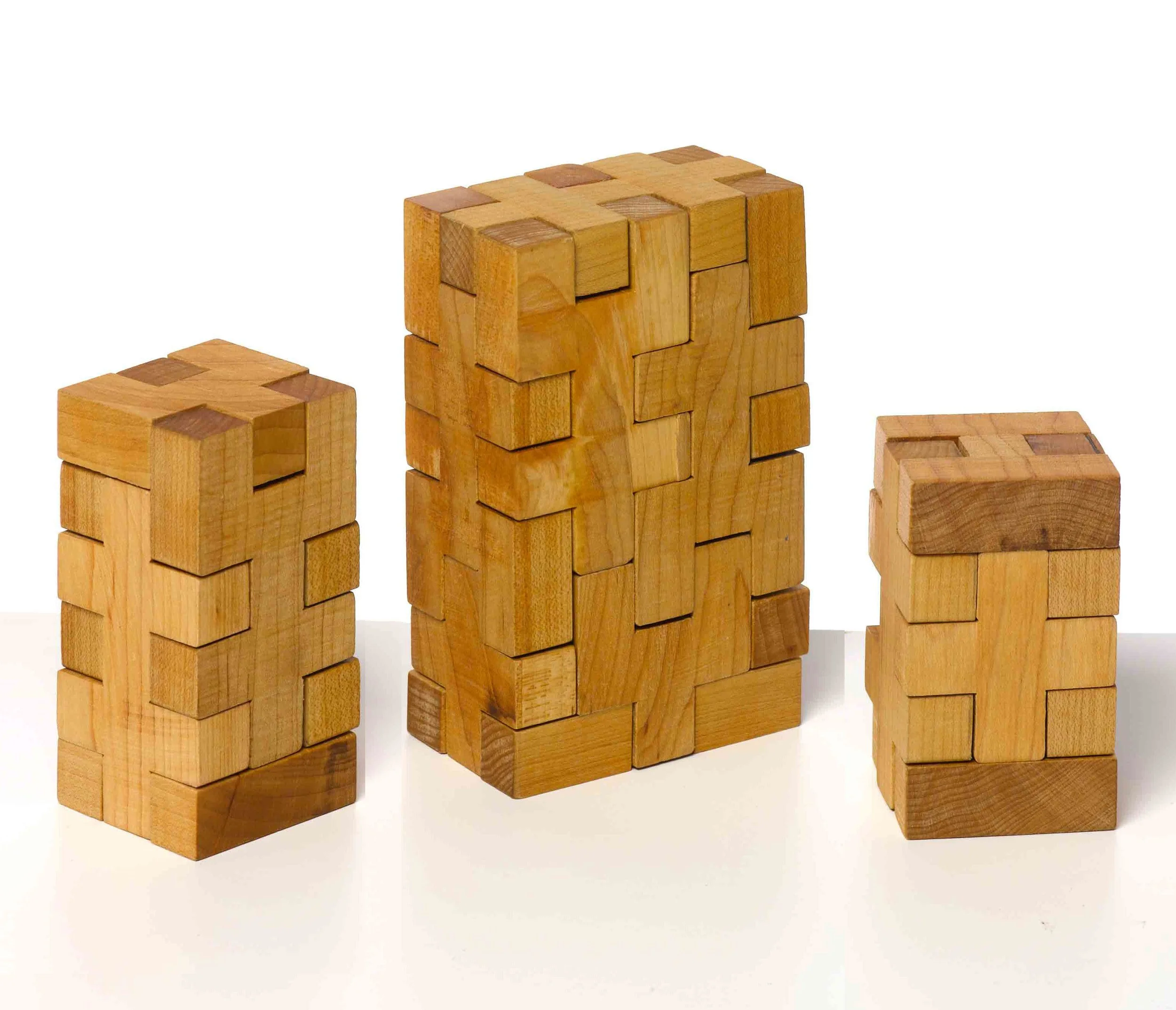 Several wooden blocks of different sizes and shapes stacked to form towers on a white background.