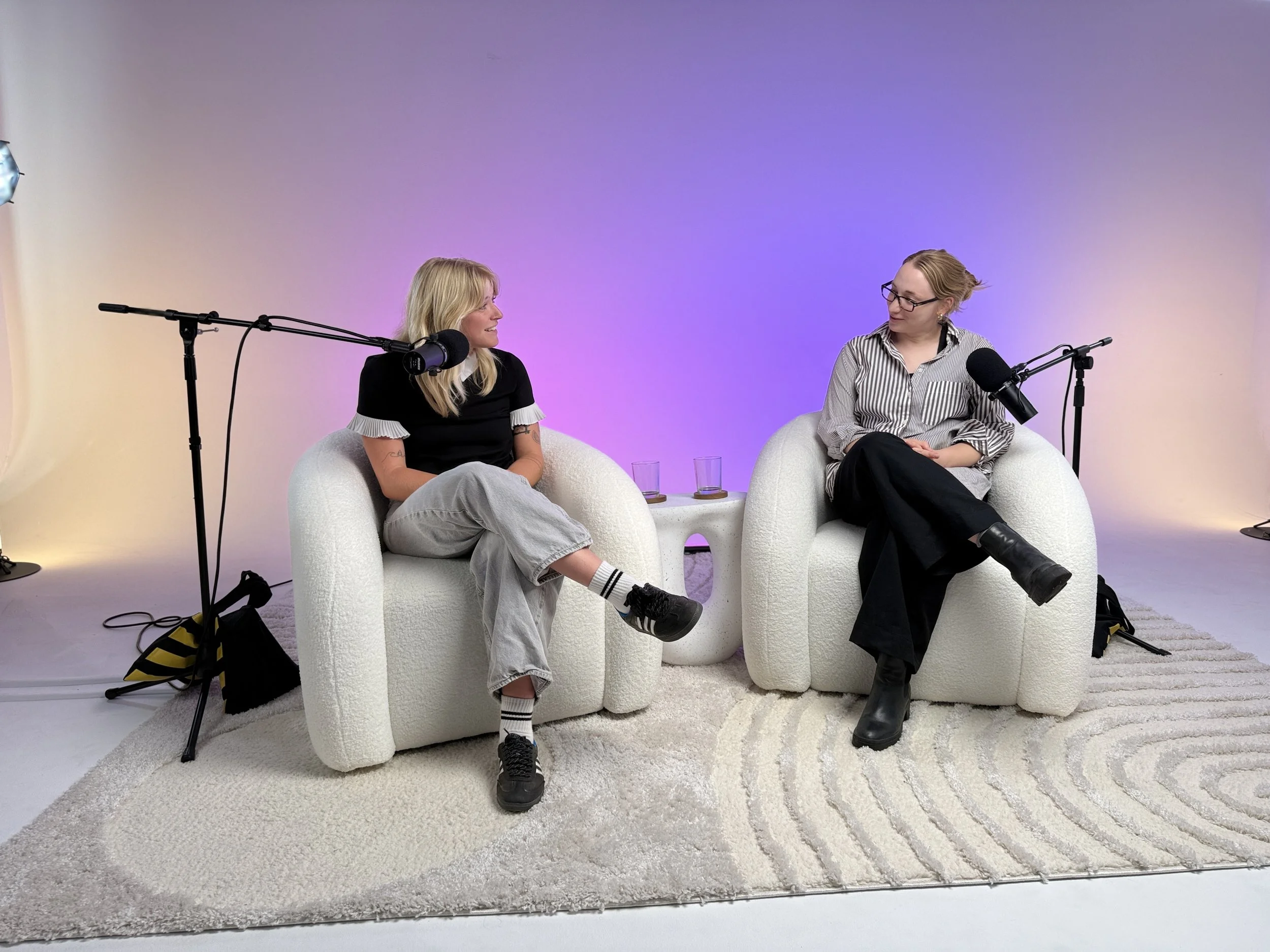 Two podcast guests seated across from each other recording a conversation at Dari studio