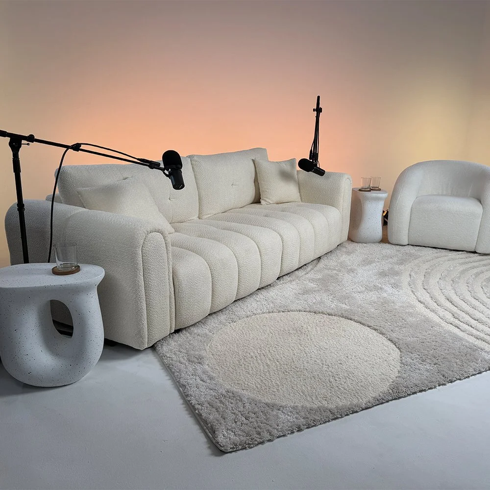 White sofa and lounge chair podcast set with boom microphones inside Dari studio