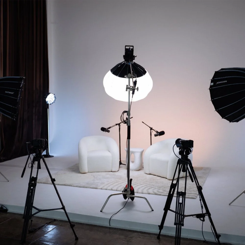Dari podcast studio setup with cameras, microphones, professional lighting, and white lounge chairs