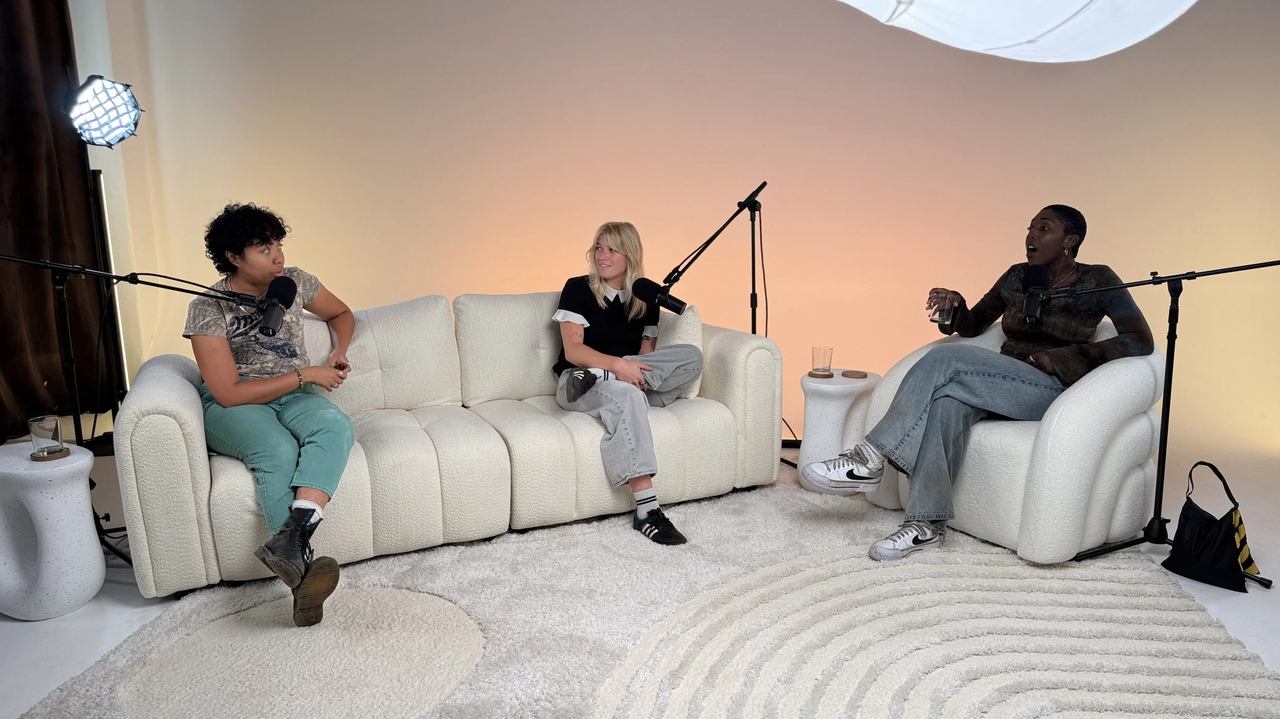 Three podcast guests recording together on the sofa and lounge chair set at Dari studio