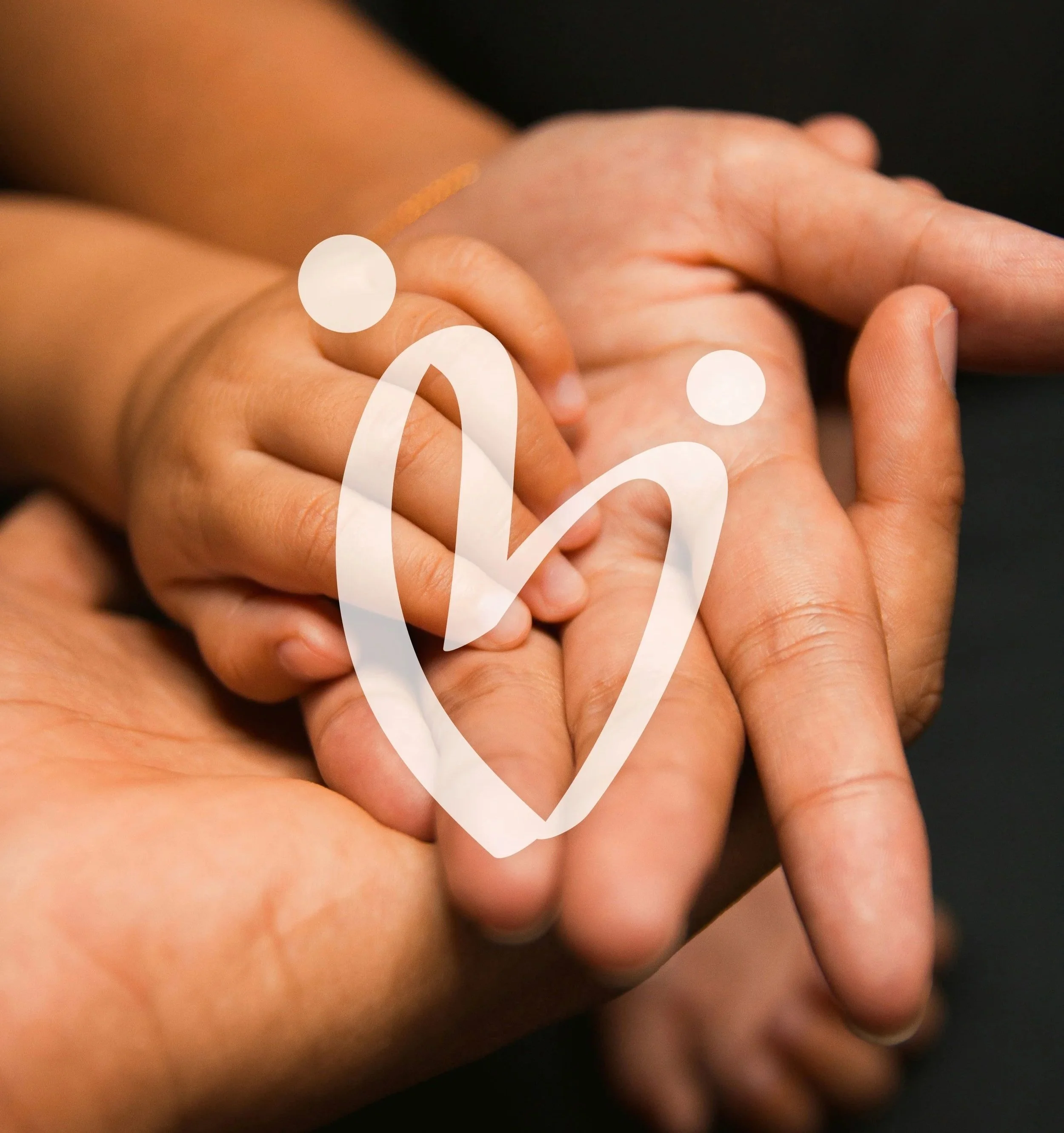 Close-up of two hands holding each other, one hand gently gripping the other, with a dark background.