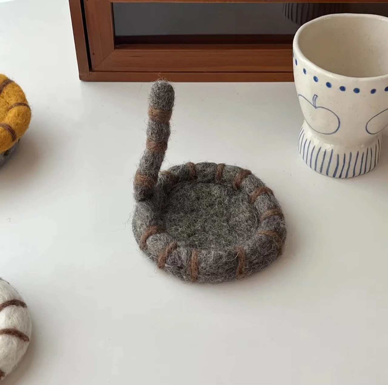 Cute handmade cat tail wool coasters with playful striped felt design, perfect for cosy coffee mugs, kawaii desk décor and aesthetic home styling.