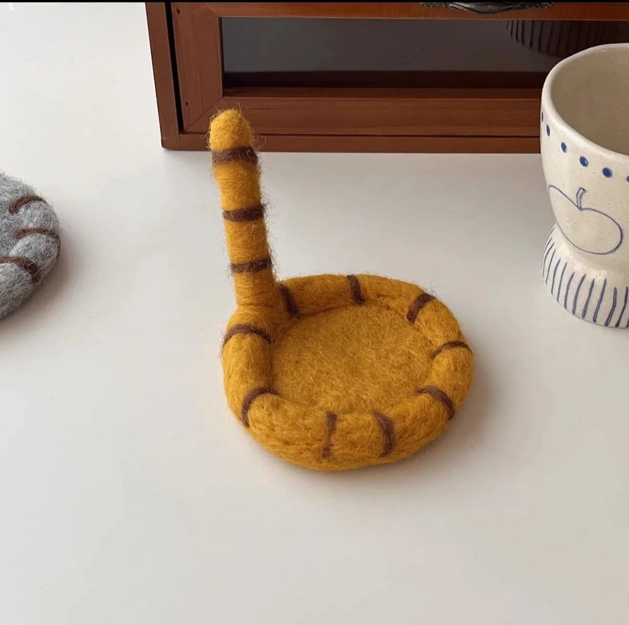 Cute handmade cat tail wool coasters with playful striped felt design, perfect for cosy coffee mugs, kawaii desk décor and aesthetic home styling.