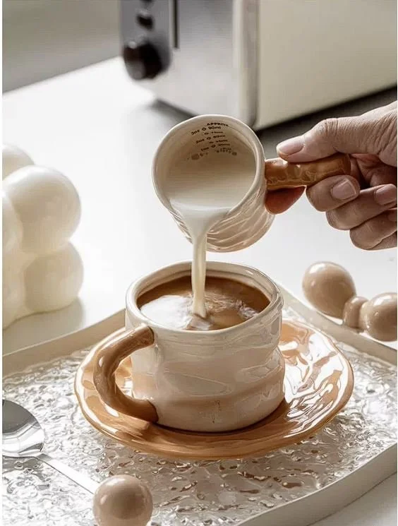 Modern ceramic espresso cup set with matching saucer and milk pitcher, featuring soft cream glaze for cosy coffee rituals and minimalist café aesthetics.