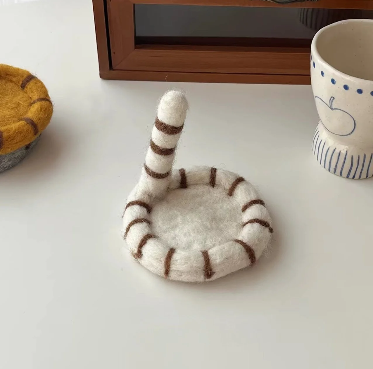 Cute handmade cat tail wool coasters with playful striped felt design, perfect for cosy coffee mugs, kawaii desk décor and aesthetic home styling.