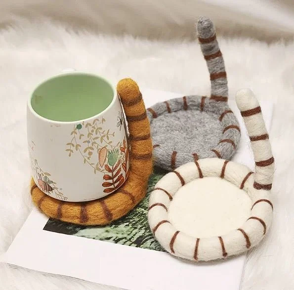 Cute handmade cat tail wool coasters with playful striped felt design, perfect for cosy coffee mugs, kawaii desk décor and aesthetic home styling.