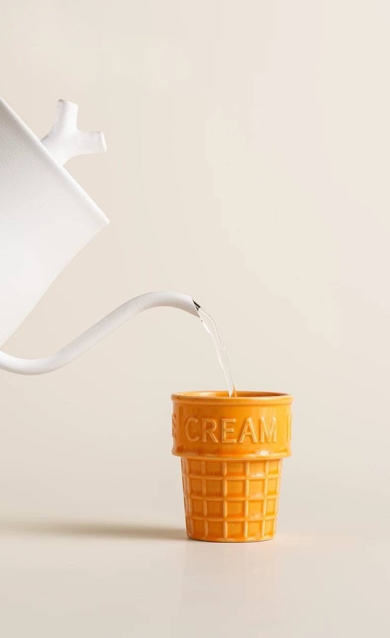 Cute ice cream cone ceramic cup with waffle texture and glossy butter-yellow glaze, perfect for coffee, desserts and playful café-inspired kitchen décor.