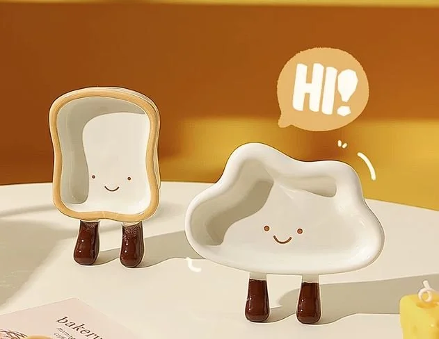 Cute cloud and toast-shaped ceramic snack plates with playful dangling legs, perfect for desserts, dipping sauces and cosy kawaii kitchen décor.