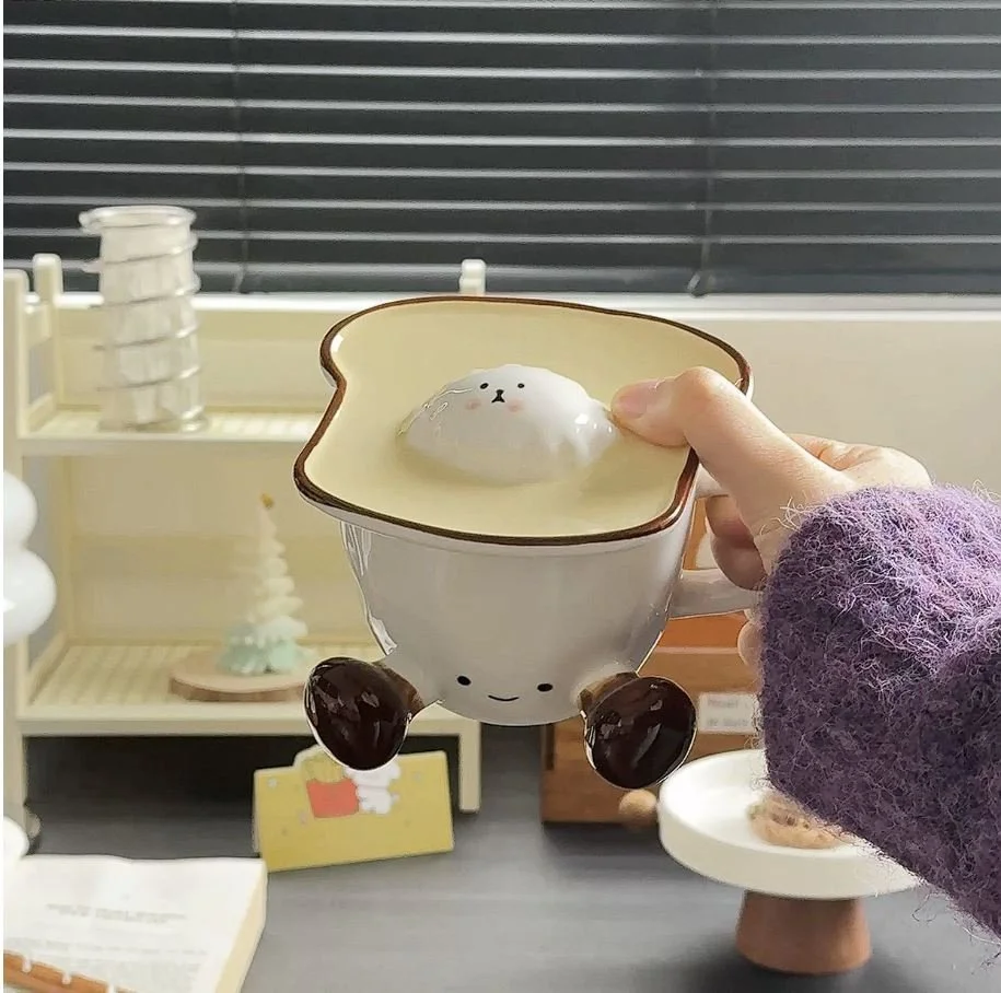 Cute toast-inspired ceramic mug with playful dangling legs and matching character lid, perfect for cosy coffee, milk, tea and kawaii desk décor.