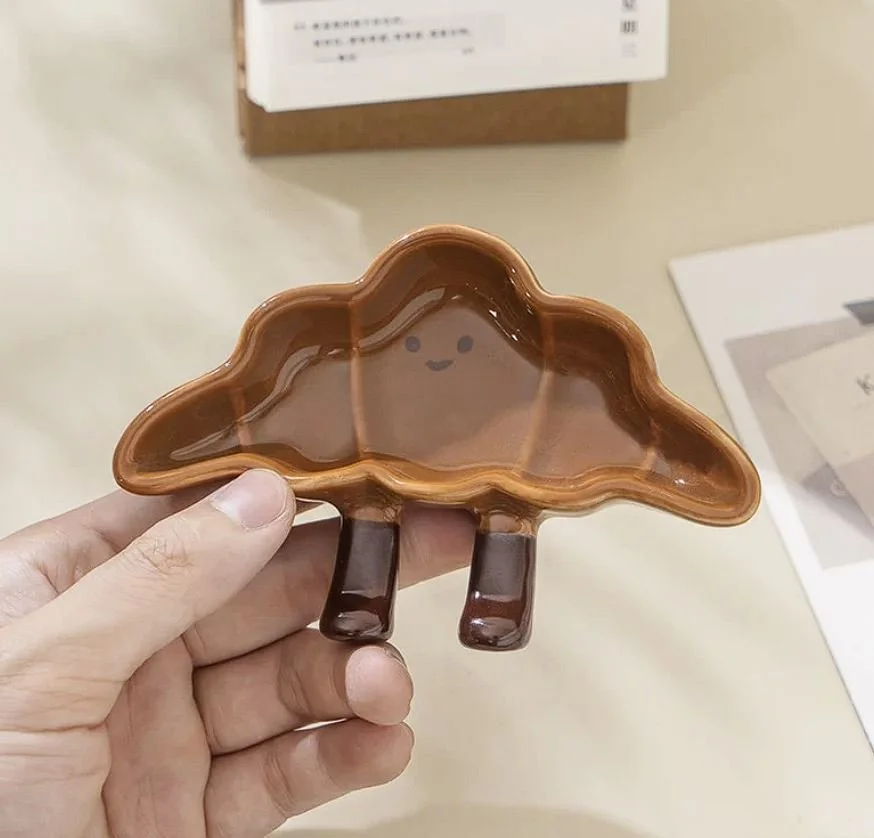 Cute croissant-shaped ceramic sauce plates with playful dangling legs, perfect for snacks, desserts, dipping sauces and cosy kawaii kitchen décor.