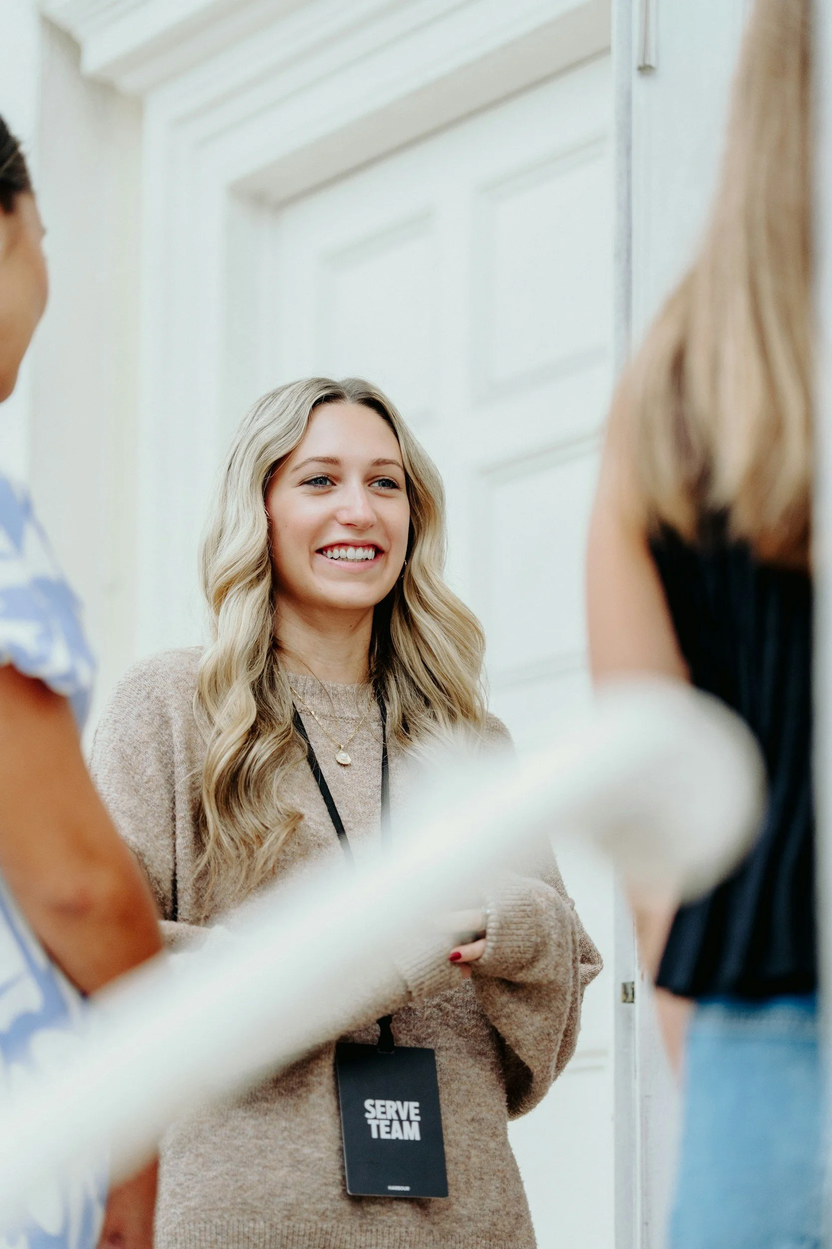 Stock photo of a woman standing with arms crossed, listening attentively.