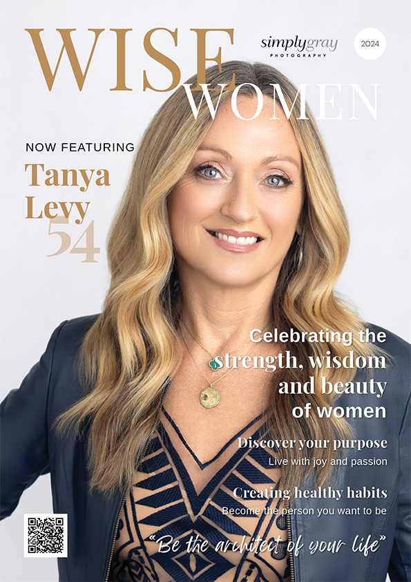 Cover of a magazine titled 'Wise Women,' featuring a smiling woman with long blonde hair wearing a dark blazer and a patterned top. The cover highlights Tanya Levy, age 54, and includes headlines about strength, wisdom, beauty, purpose, healthy habits, and inspiring quotes.
