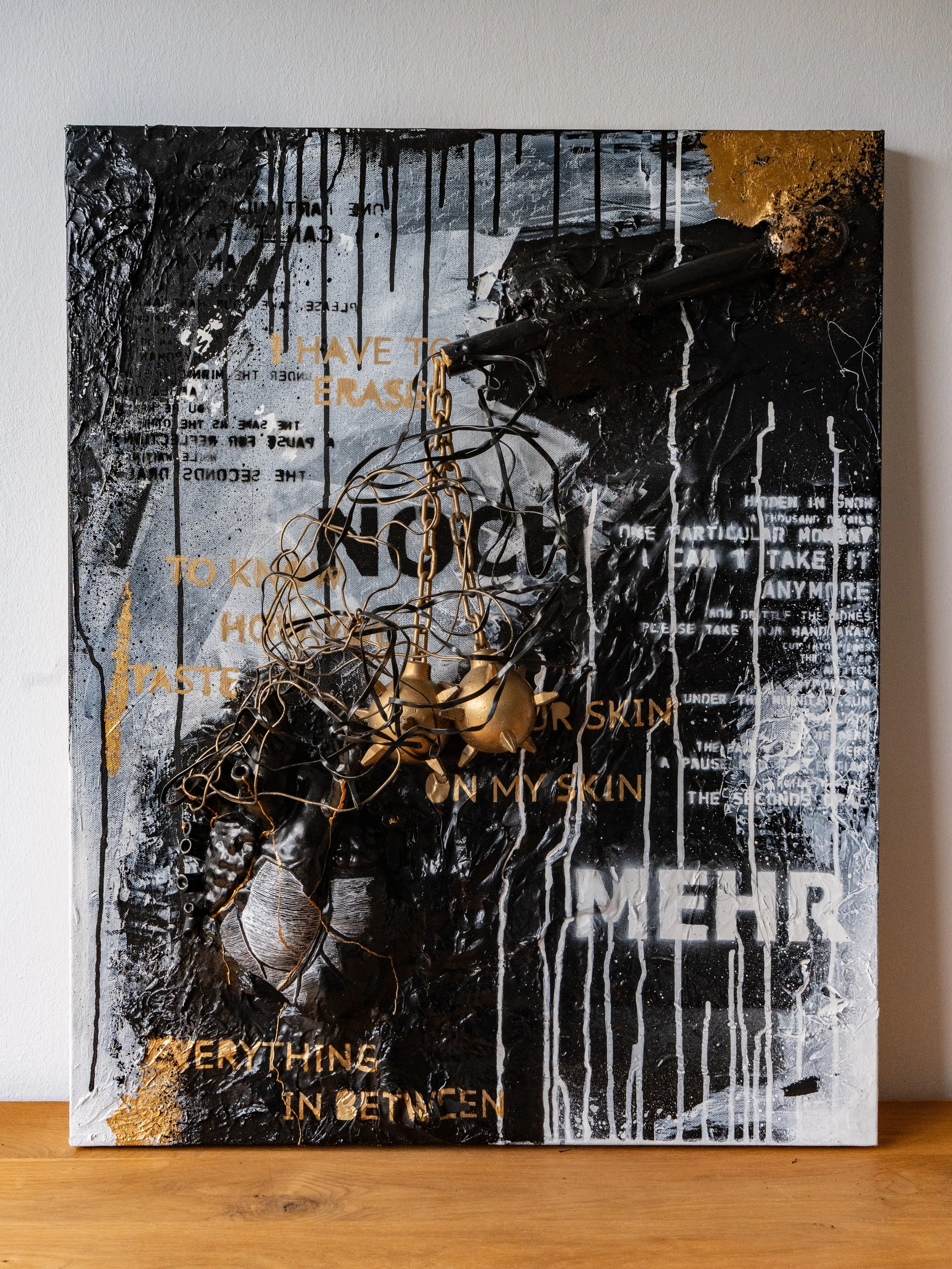 An abstract mixed-media artwork with black, white, gold, and gray textures and text. The text includes phrases like "I HAVE TO ERASE," "TO KNOW HOW I SKIN," and other partially obscured words.