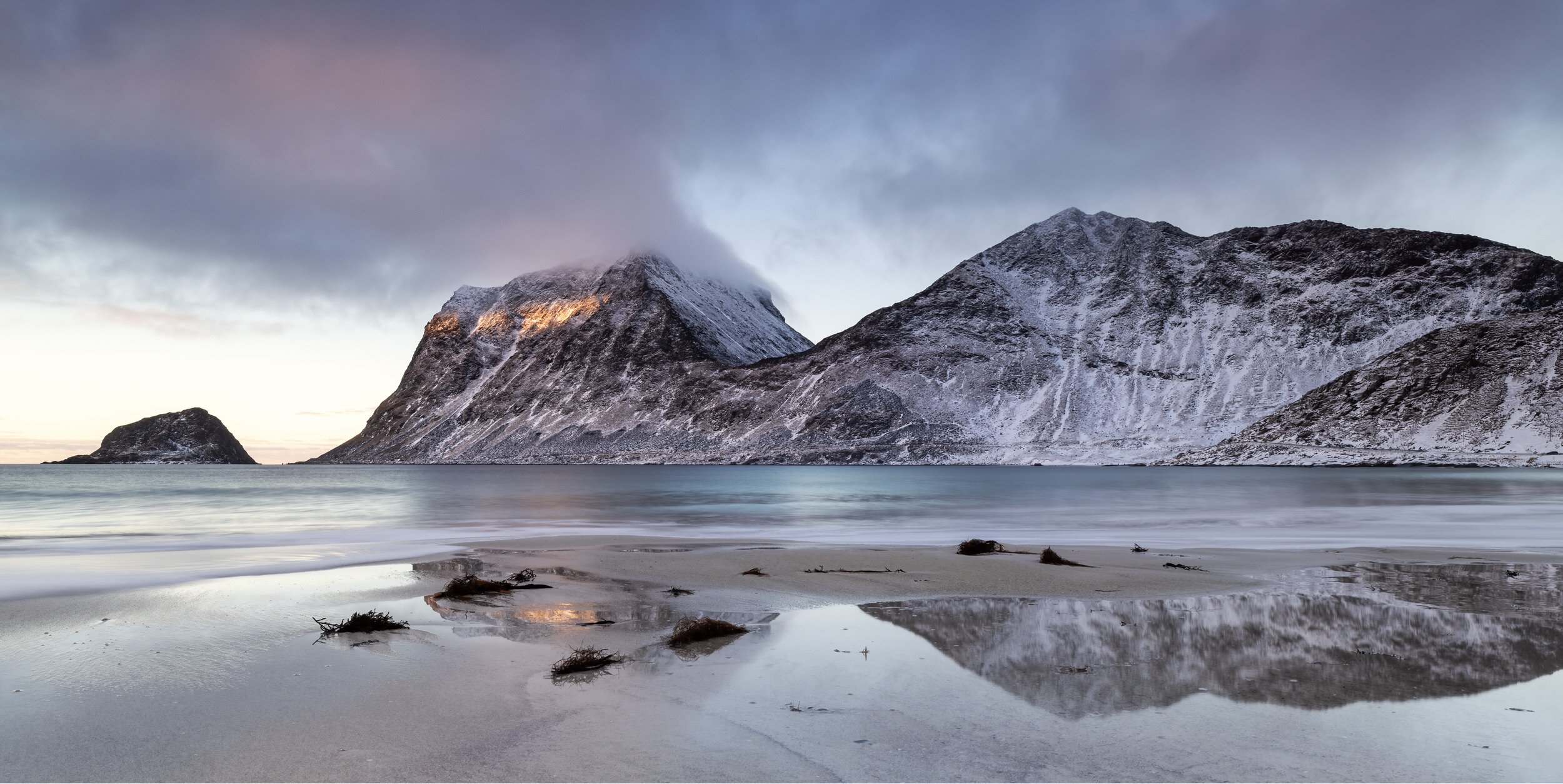 Beach reflections at Sunset Midwinter on Vik Beach in the Lofoten Islands, Norway.
