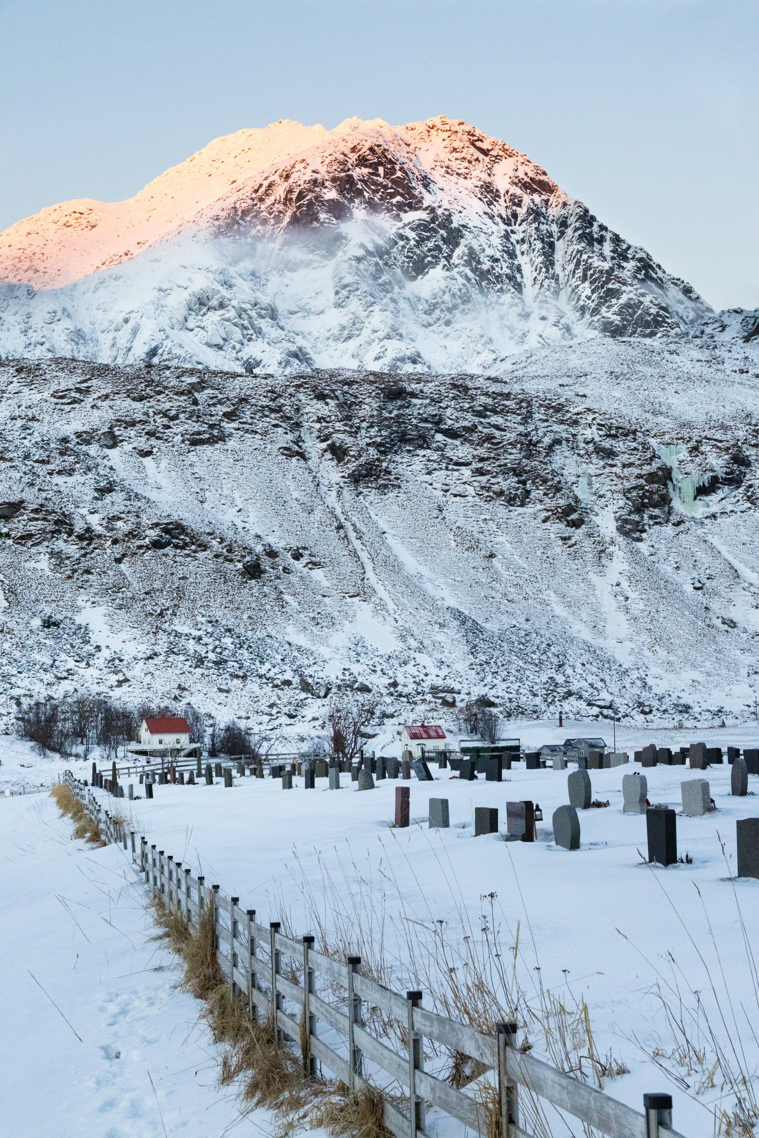Sun tipped mountains overlooking the graveyard at Vik beach, Lofoten Islands, Norway.