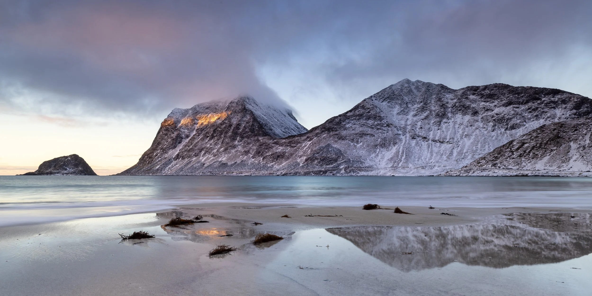 Midwinter reflections at Sunset on Vik Beach, Lofoten Islands, Norway.