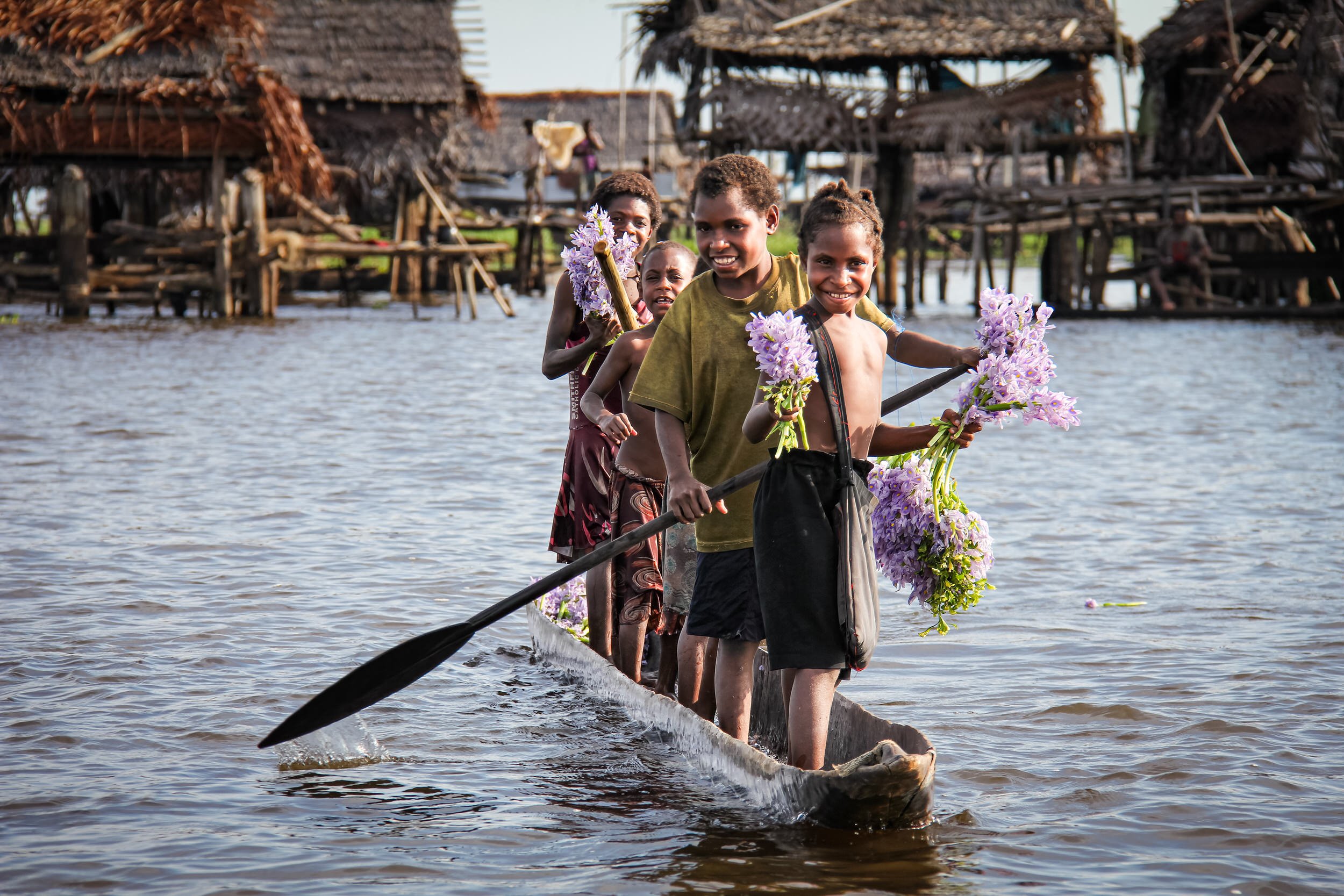 Welcoming children in canoe at the village on water, Sepik River, Papua New Guinea.